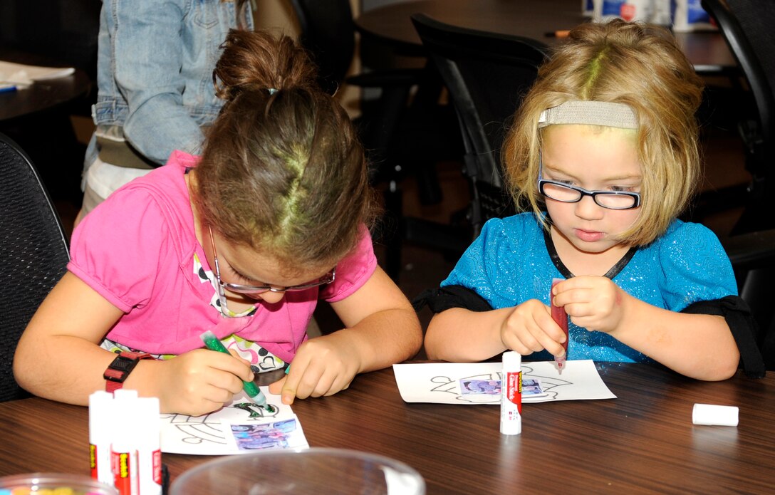 Dylan Swan (left), 7, and her sister Neela (right), 6, color pictures for their deployed father during a Holiday Care Package class  in the Airman and Family Readiness Center classroom at Ellsworth Air Force Base, S.D., Nov. 3, 2012. The class was one of several the AFRC hosts to help strengthen military families by offering support through interaction with others who are dealing with the same stressors, including deployments or remote assignments. (U.S. Air Force photo by Airman Ashley J. Woolridge/Released)