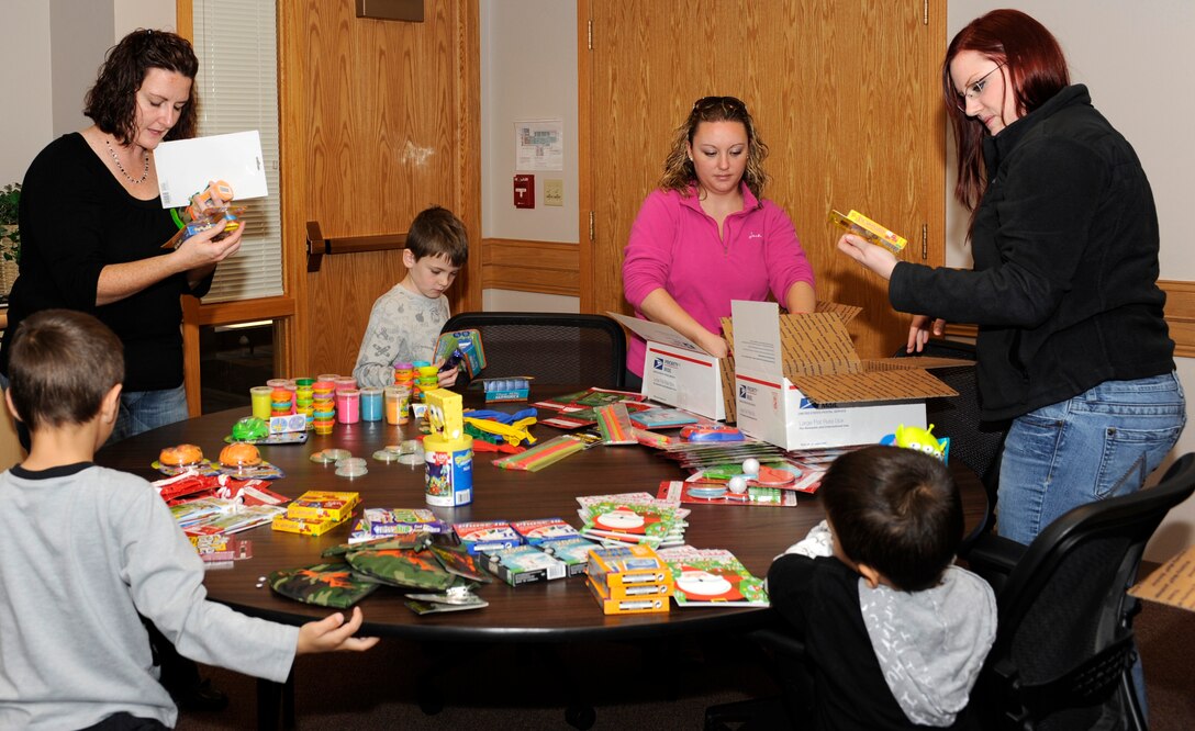 Spouses and children of deployed Airmen or those serving on a remote assignment browse through assorted novelty items provided by the Airman and Family Readiness Center during a Holiday Care Package class in the AFRC classroom at Ellsworth Air Force Base, S.D., Nov. 3, 2012. The AFRC hosted the class to give families a chance to socialize and create a care package to brighten their Airman?s holiday season. (U.S. Air Force photo by Airman Ashley J. Woolridge/Released)