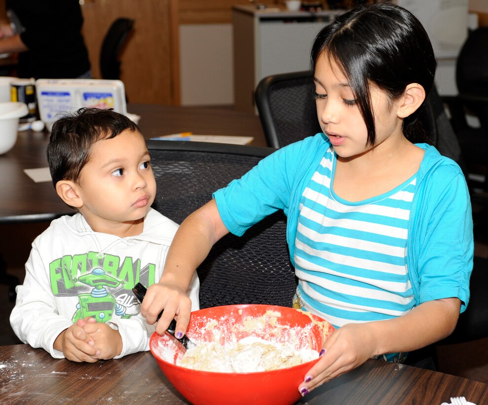 Conner Marquez, 3, watches his sister Marissa, 9, mix cookie dough during a Holiday Care Package class in the Airman and Family Readiness Center classroom at Ellsworth Air Force Base, S.D., Nov. 3, 2012. The children helped make cookie dough and other crafts to include in a care package for their deployed father. (U.S. Air Force photo by Airman Ashley J. Woolridge/Released)