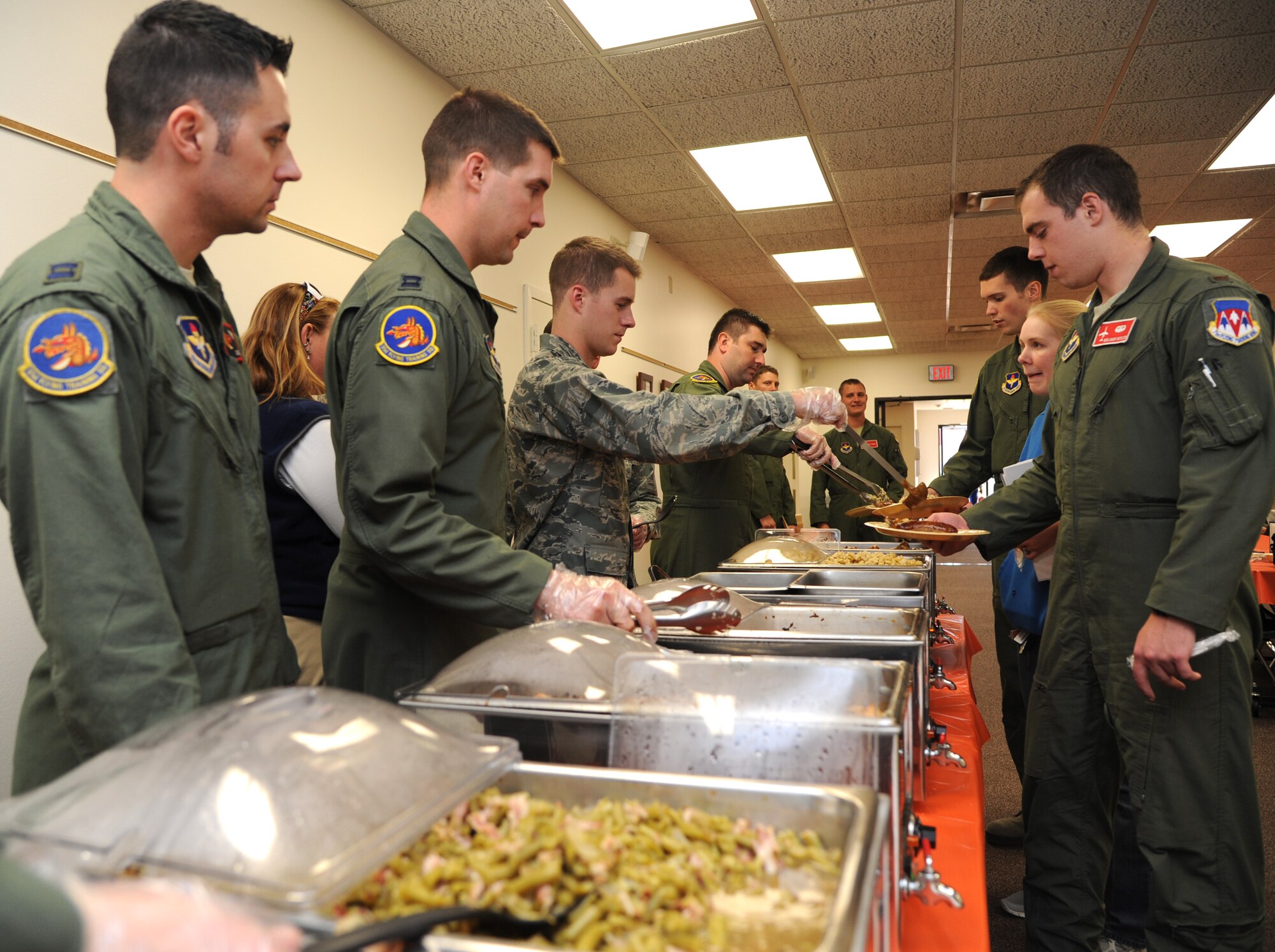 Personnel from the 33rd Flying Training Squadron serve hungry guests during the October Singles’ International Gourmet Meal Opportunity held Oct. 29 in the Community Chapel Activity Center at Vance Air Force Base, Okla. Twenty-two volunteers from the 33rd FTS filled the bellies of 161 guests. (U.S. Air Force photo/ Airman 1st Class Frank Casciotta)