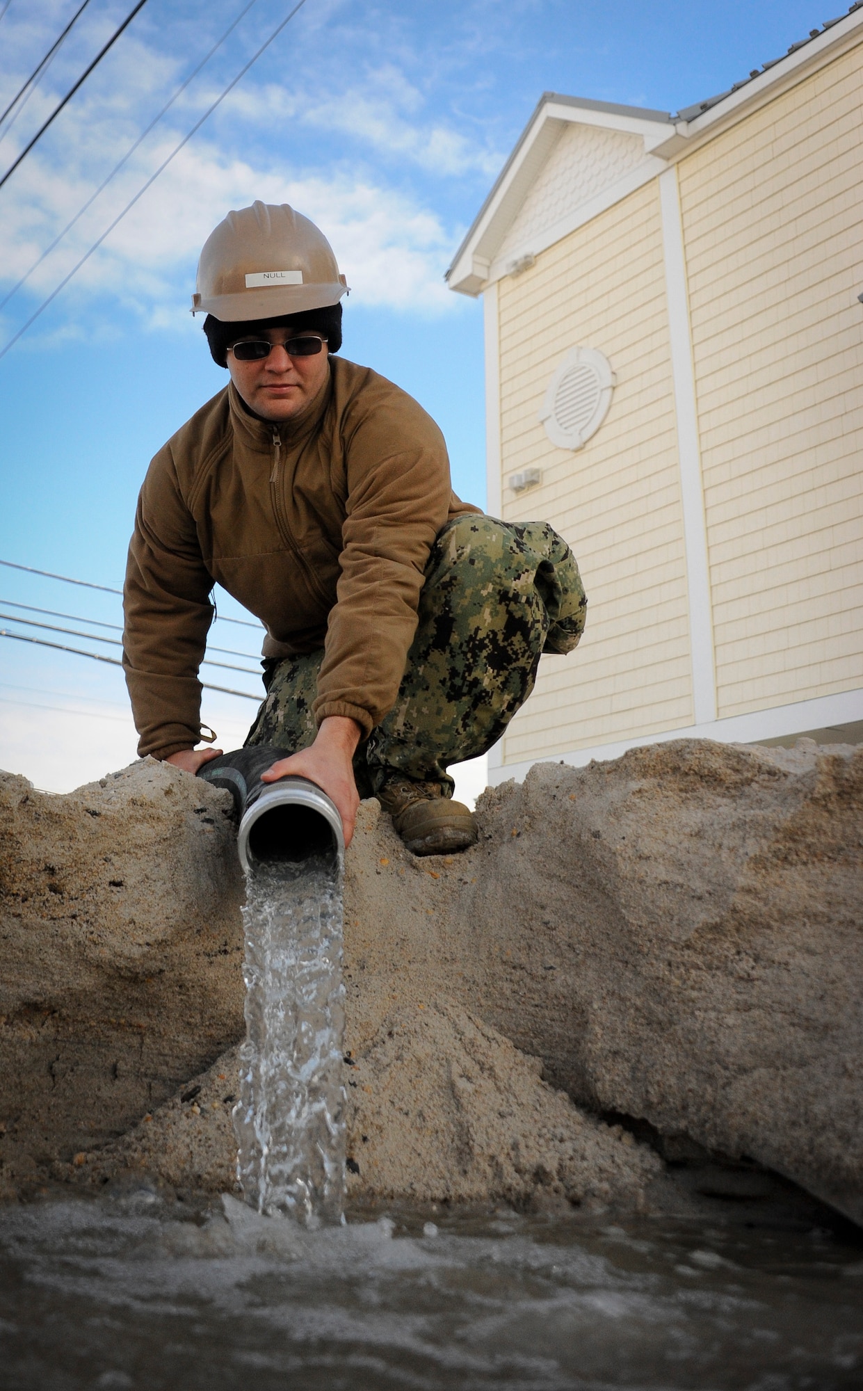 JOINT BASE MCGUIRE-DIX-LAKEHURST, N.J.— Seaman Adam Mull, Naval Mobile Construction Battalion 11 utilitiesman, positions a water pump’s hose into a drainage area Nov. 6, 2012, Seaside Heights, N.J. The NCMB-11 Sailors, or “Seabees”, are lending their engineering and disaster-relief expertise to the devastated Jersey Shore. The Seabees are using their heavy equipiment, or “green gear,” to move large debris such as wrecked cars or boats strewn about by the storm. Mull hails from Van Wert, Ohio. (U.S. Air Force Ryan Throneberry/Released)