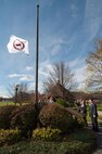 HANSCOM AIR FORCE BASE, Mass. – Family members of retired Army Lt. Col. William J. Powers and retired Air Force Master Sgt. Thomas J. Schubmehl watch as the Memorial Park flag is raised in their loved ones honor Nov. 1. Powers and Schubmehl, two former Hanscom personnel, were also honored with a tree and bronze plaque dedicated in their memory. (U.S. Air Force photo by Rick Berry)