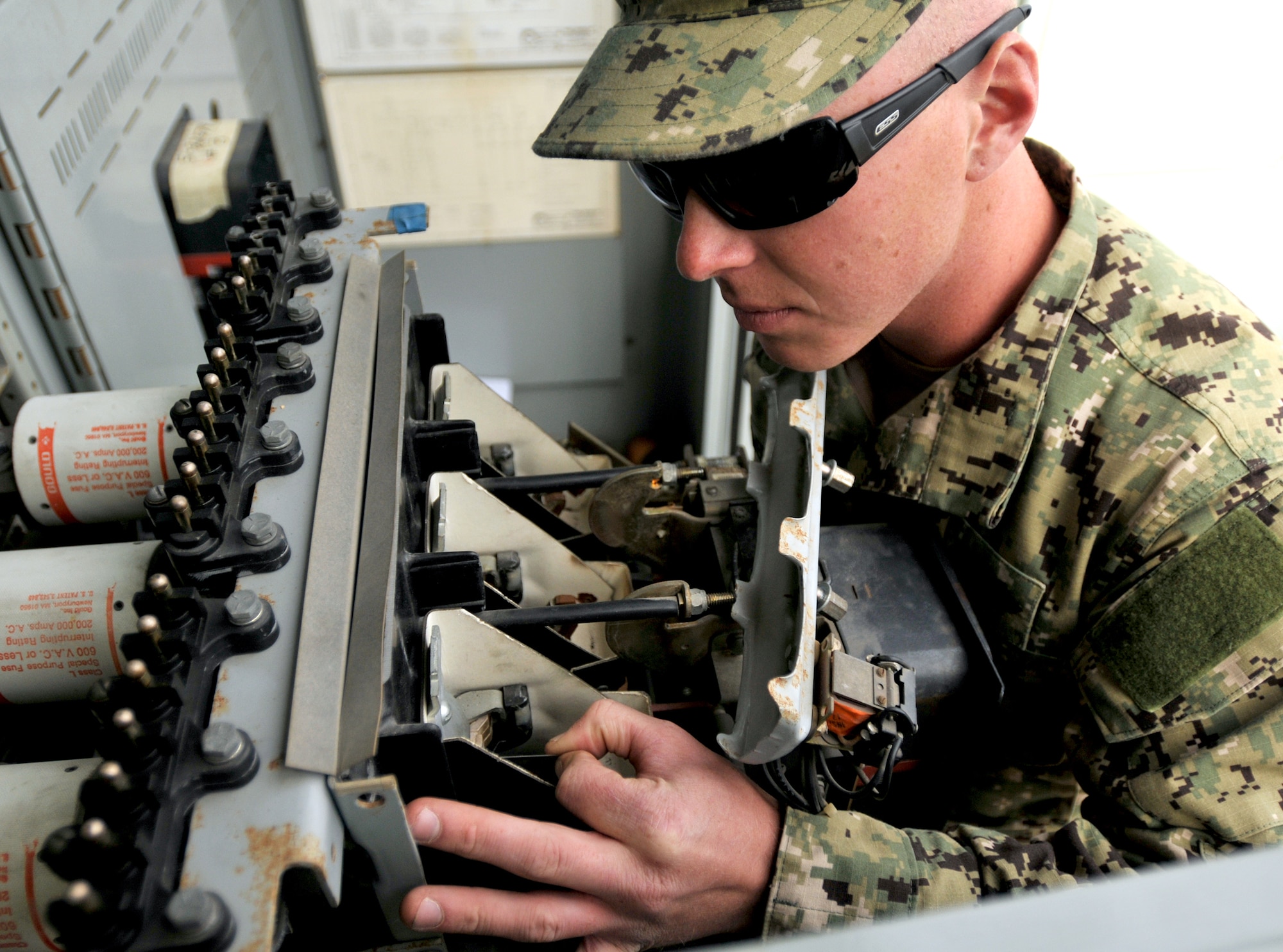 Petty Officer 2nd Class Luke Timmerman, a member of the U.S. Navy Mobile Utilities Support Equipment team, measures the contact depression on a low voltage power circuit breaker at the U.S. Strategic Command building on Offutt Air Force Base, Neb. Oct. 30. (U.S. Air Force photo by Tech. Sgt. Markus M. Maier/Released)