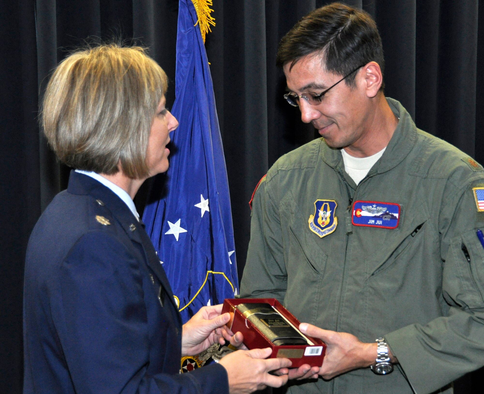 Air Force Reserve Lt. Col. Lynn Jui (left) thanks her husband, Maj. Jim Jui, with a gift of appreciation Nov. 4 during a change of command ceremony at Peterson Air Force Base, Colo. Jui passed the squadron's guidon to incoming commander Lt Col. Brian McCullagh. McCullagh comes to the 302nd LRS commander position after serving as the operations officer at the 50th Aerial Port Squadron, March Air Reserve Base, Calif. Jui goes on to become an Individual Mobilization Augmentee based at F.E. Warren AFB in Wyoming. (U.S. Air Force photo/Staff Sgt. Stephen J. Collier)