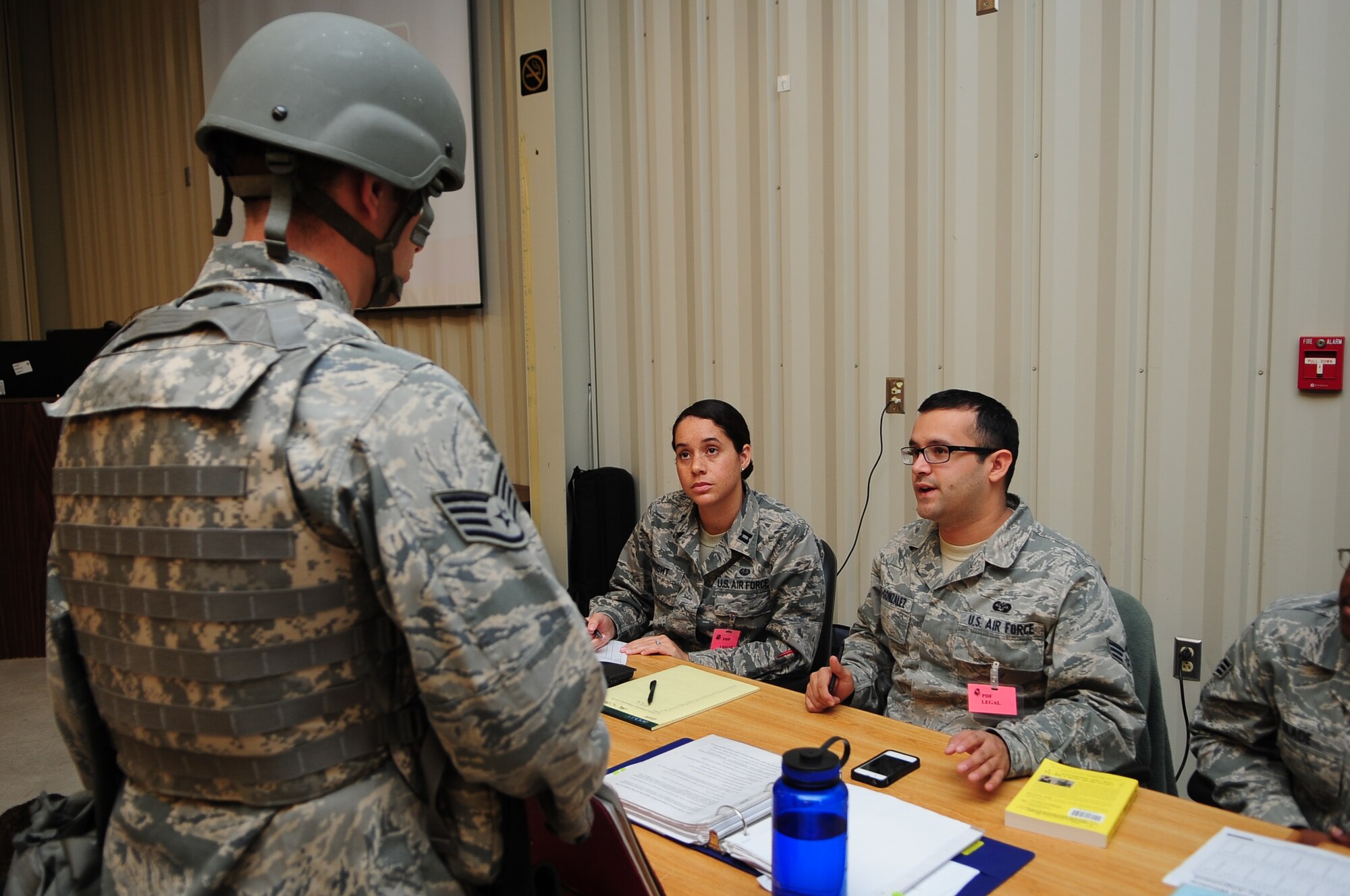 U.S. Air Force Airman Andres Olaya-Gonzalez, 4th Fighter Wing paralegal, speaks to Staff Sgt. Matthew Halligan, 4th Security Forces Squadron military working dog handler, during Operational Readiness Exercise Coronet Warrior 12-05 on Seymour Johnson Air Force Base, N.C., Nov. 5, 2012. Representatives from the legal office are present at the Personnel Deployment Facility to offer Airmen advice prior to their departure. (U.S. Air Force photo/Airman 1st Class Aubrey White/Released)
