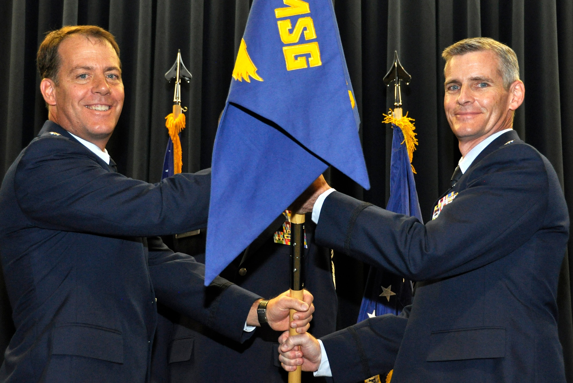 Air Force Reserve Lt. Col. Brian McCullagh (right) accepts the 302nd Logistics Readiness Squadron guidon from Lt. Col. Michael Smith Nov. 4 during a change of command ceremony at Peterson Air Force Base, Colo. McCullagh accepted command of the squadron from its outgoing commander, Lt. Col. Lynn Jui, after serving as the operations officer at the 50th Aerial Port Squadron, March Air Reserve Base, Calif. Jui goes on to become an Individual Mobilization Augmentee based at F.E. Warren AFB in Wyoming. Smith is the acting commander for the 302nd Mission Support Group, the 302nd LRS's parent organization. (U.S. Air Force photo/Staff Sgt. Stephen J. Collier)