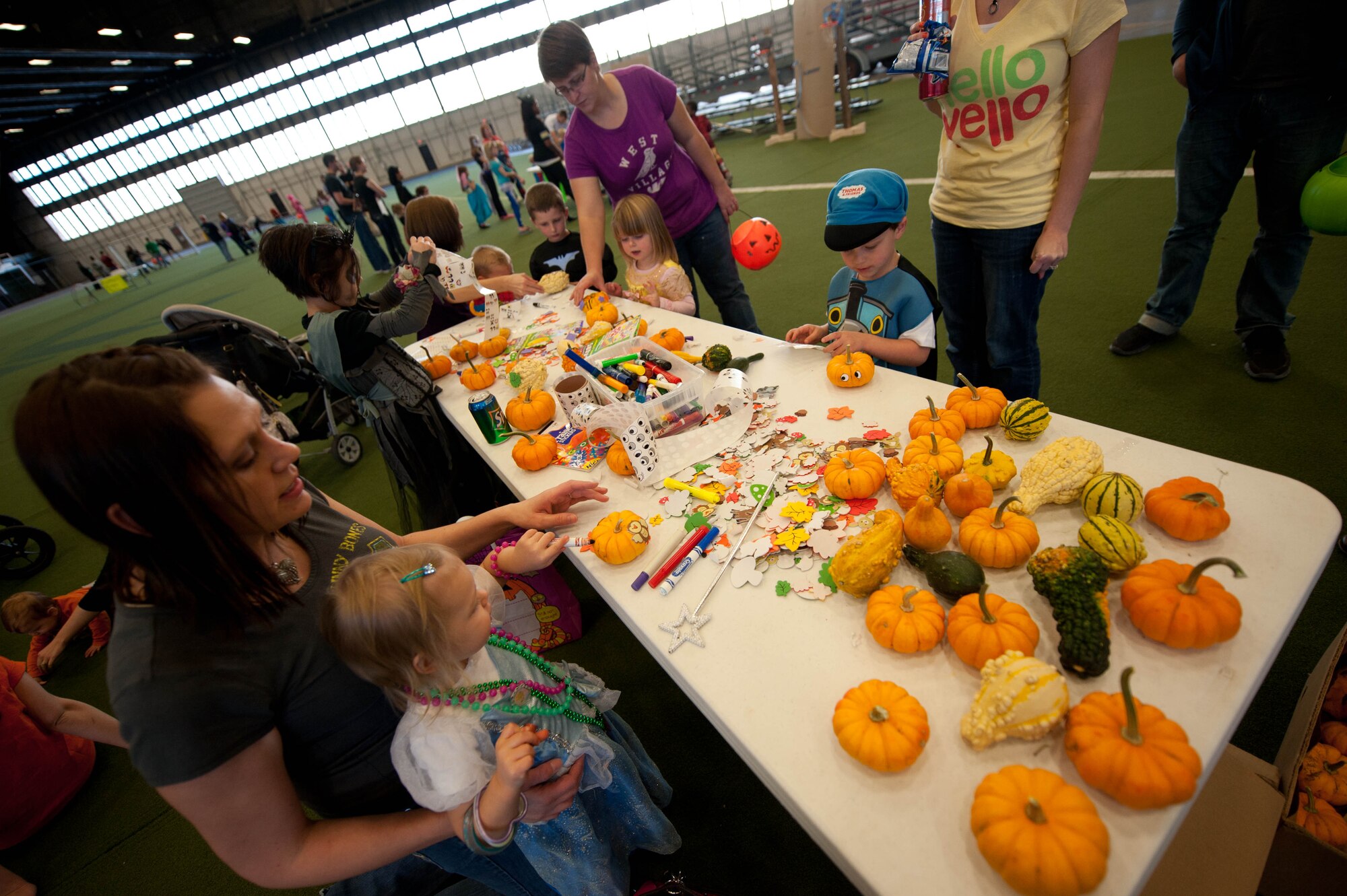 Children decorate miniature pumpkins during the Fall Festival hosted by 28th Bomb Wing Chapel staff in the Pride Hangar at Ellsworth Air Force Base, S.D., Oct. 31, 2012. Airmen and families gathered to enjoy a night of pumpkin decorating, games for all ages, face painting, bouncy castles, costume contests, prizes, and more. (U.S. Air Force photo by Airman 1st Class Zachary Hada/Released)