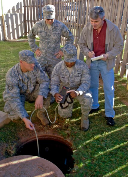 Staff Sgt. Shawn Gallagher, 2nd Aerospace Medical Squadron Bioenvironmental Engineering craftsman, and Keith Lear, 2nd Bomb Wing Safety, review readings from an atmospheric monitoring meter taken by Staff Sgt. Shane Derrick  and Airman 1st Class Brandon Curry, 2nd Civil Engineering Squadron electrical shop, on Barksdale Air Force Base, La., Nov 7. Routine testing of man-holes around the base ensure airborne hazards are or are not present in the confined spaces. (U.S. Air Force photo/Staff Sgt. Jason McCasland)(RELEASED)
