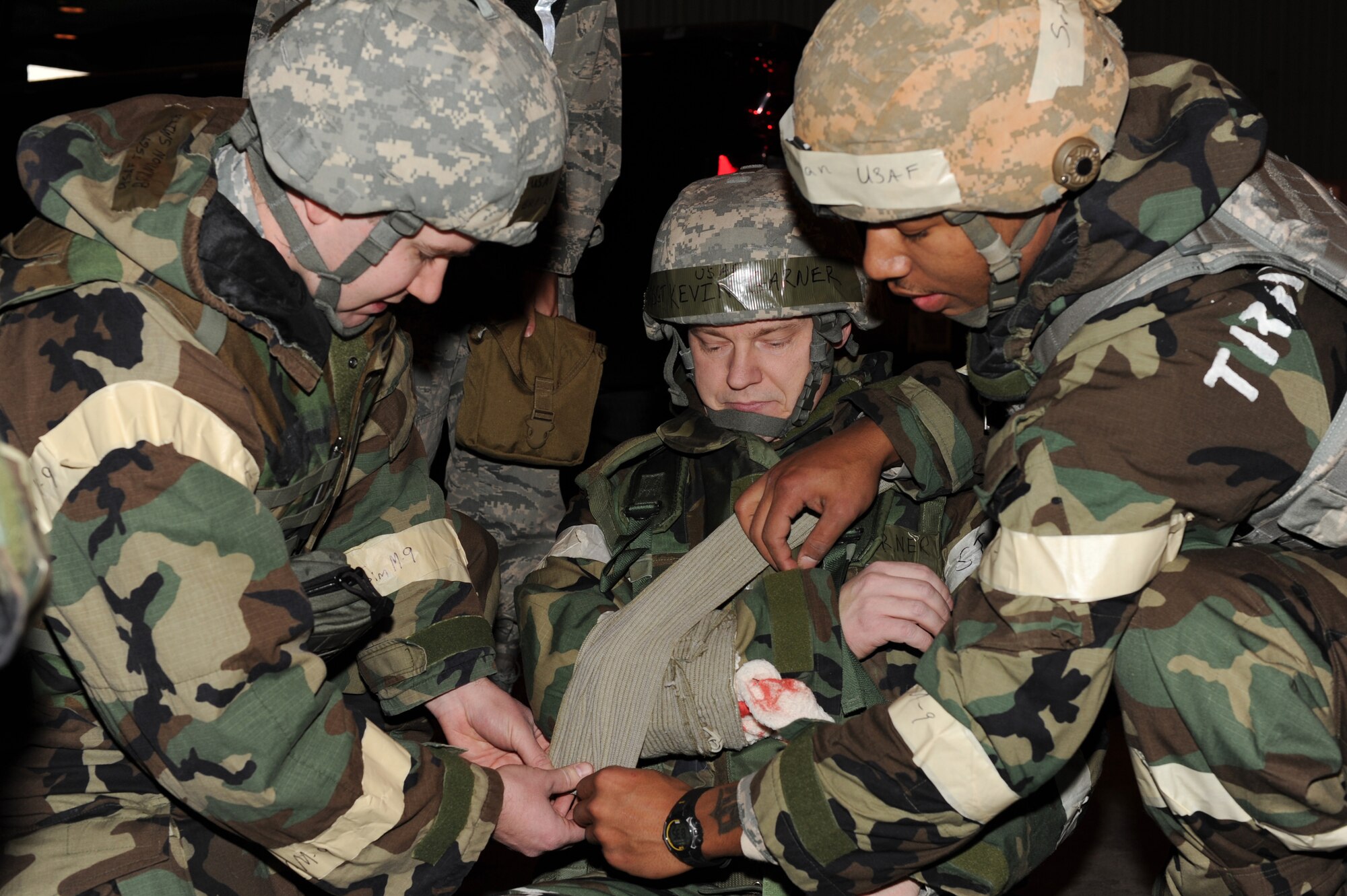 U.S. Air Force Tech. Sgt. Brandon Smith, 354th Civil Engineer Squadron NCO in charge of emergency management, and Senior Airman Veon Selman, 354th Security Forces Squadron response force leader, performs self aid buddy care on Master Sgt. Kevin Garner, 354th Communications Squadron NCO in charge of infrastructure, during an operational readiness exercise Nov. 6, 2012, Eielson Air Force Base, Alaska. The week-long exercise is designed to give Icemen the opportunity to test their ability to go through the deployment process and respond to various scenarios. (U.S. Air Force photo/Staff Sgt. Jim Araos)