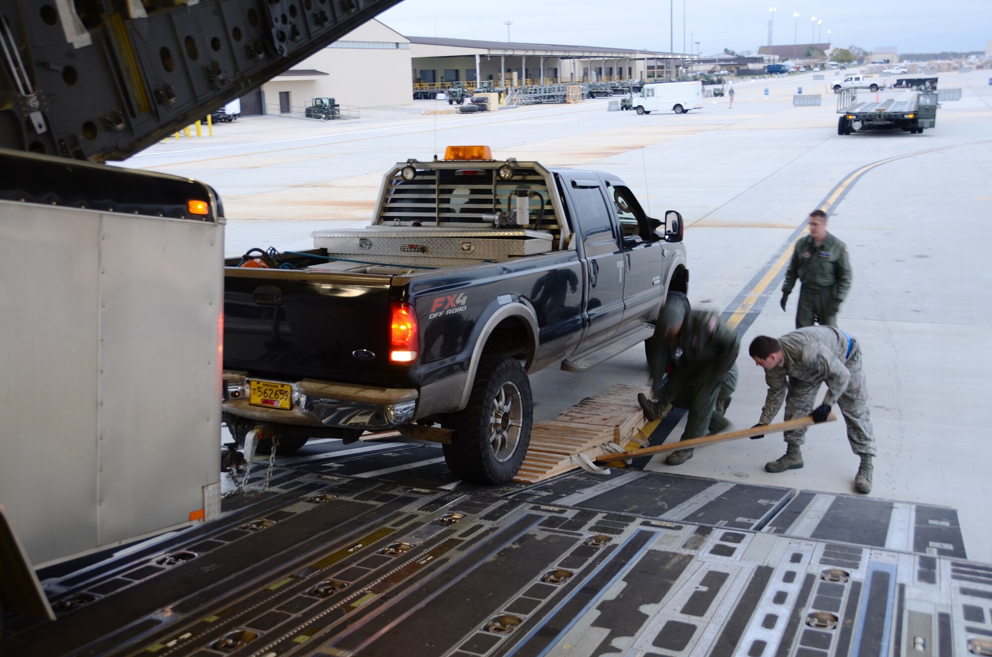 Airmen unload four heavy-duty trucks from a 445th Airlift Wing C-17 Globemaster III at Joint Base McGuire-Dix-Lakehurst, N.J. Nov. 7.  Members of the 445th transported cargo from Joint Base Lewis-McChord Wash. to Joint Base McGuire-Dix-Lakehurst, N.J. Nov. 6 and 7 in support of disaster relief efforts in the wake of Hurricane Sandy. (U.S. Air Force Photo/Capt. John Stamm)