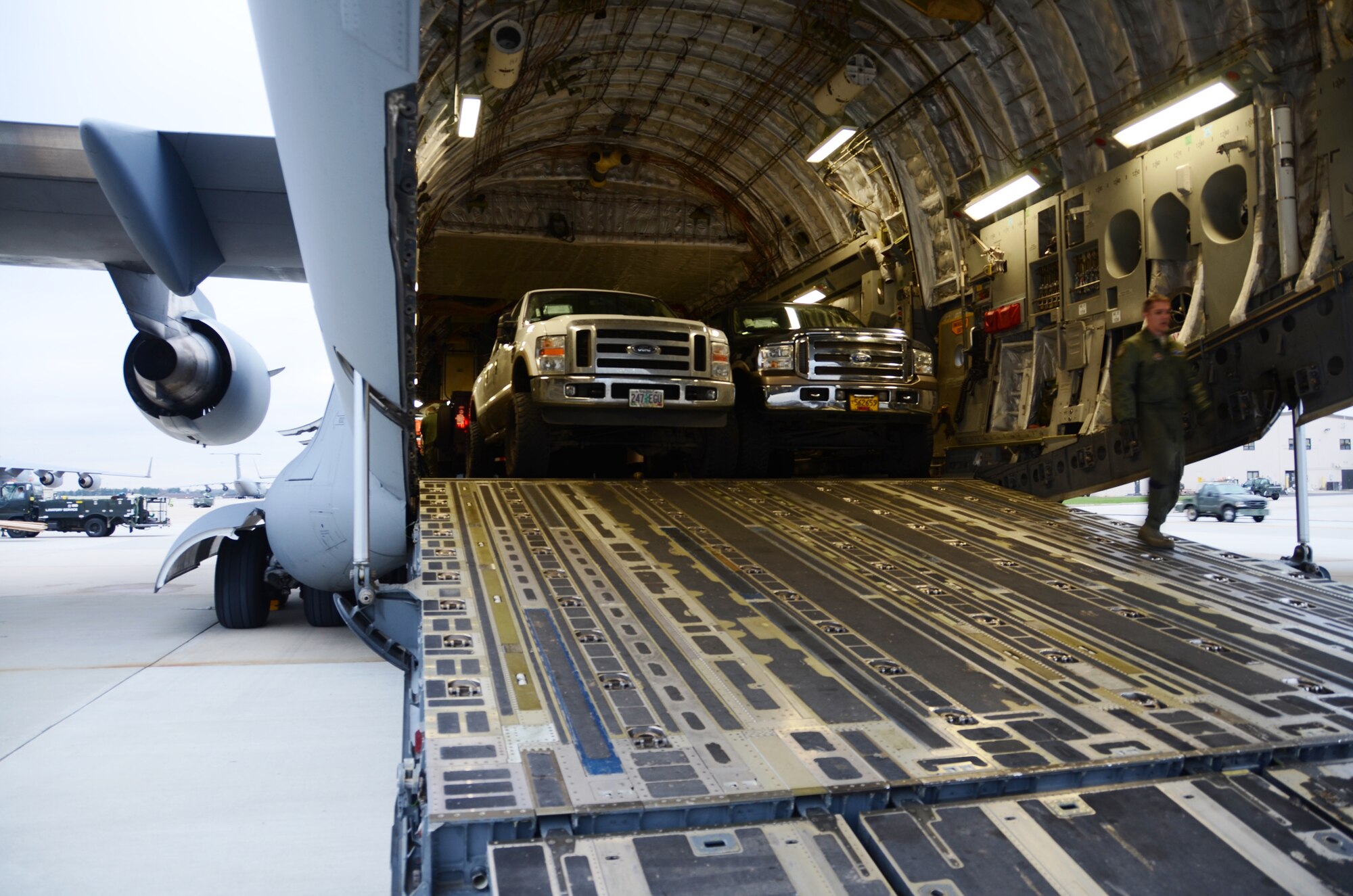 Airmen unload four heavy-duty trucks from a 445th Airlift Wing C-17 Globemaster III at Joint Base McGuire-Dix-Lakehurst, N.J. Nov. 7.  Members of the 445th transported cargo from Joint Base Lewis-McChord Wash. to Joint Base McGuire-Dix-Lakehurst, N.J. Nov. 6 and 7 in support of disaster relief efforts in the wake of Hurricane Sandy. (U.S. Air Force Photo/Capt. John Stamm)