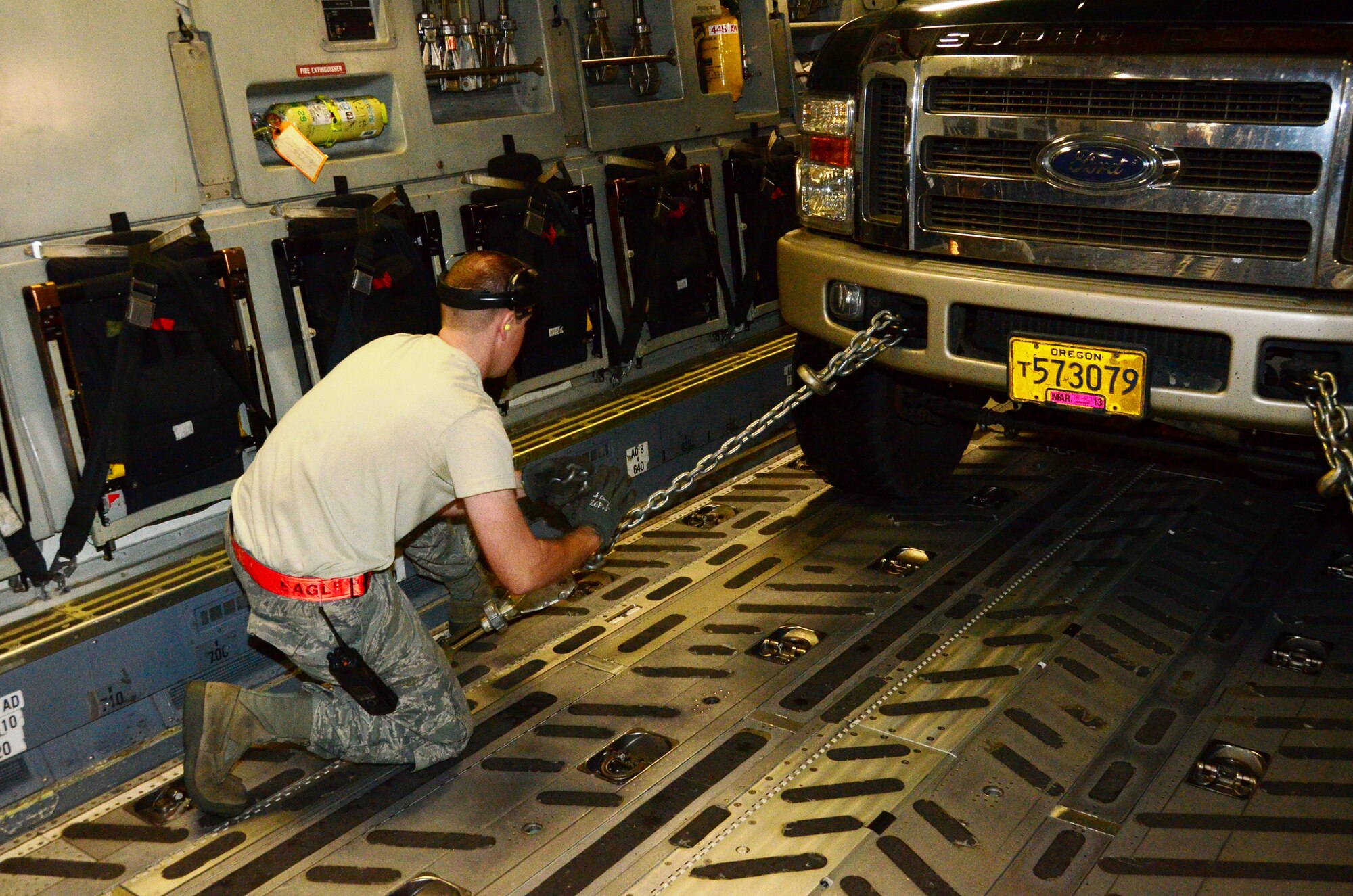 An Airman secures one of four heavy-duty trucks inside a 445th Airlift Wing C-17 Globemaster III cargo aircraft at Joint Base Lewis-McChord, Wash. Nov. 6.  Members of the 445th transported cargo from Joint Base Lewis-McChord to Joint Base McGuire-Dix-Lakehurst, N.J. Nov. 6 and 7 in support of disaster relief efforts in the wake of Hurricane Sandy. (U.S. Air Force Photo/Capt. John Stamm)