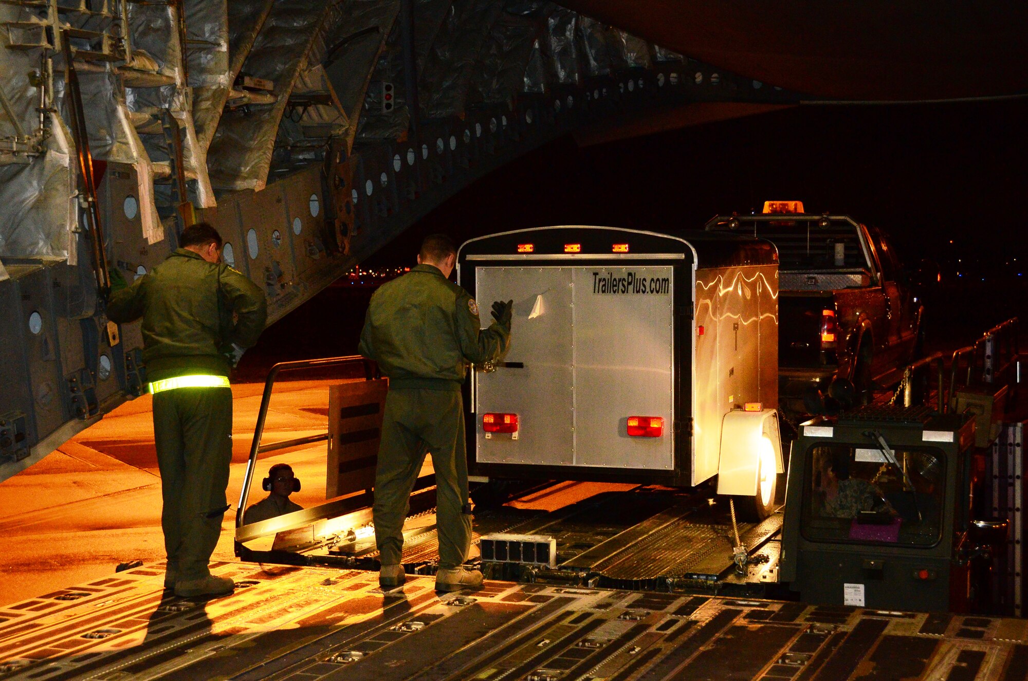 Airmen load heavy-duty trucks inside a 445th Airlift Wing C-17 Globemaster III cargo aircraft at Joint Base Lewis-McChord AFB, Wash. Nov. 6.  Members of the 445th transported cargo from Joint Base Lewis-McChord to Joint Base McGuire-Dix-Lakehurst, N.J. Nov. 6 and 7 in support of disaster relief efforts in the wake of Hurricane Sandy. (U.S. Air Force Story/Capt. John Stamm)