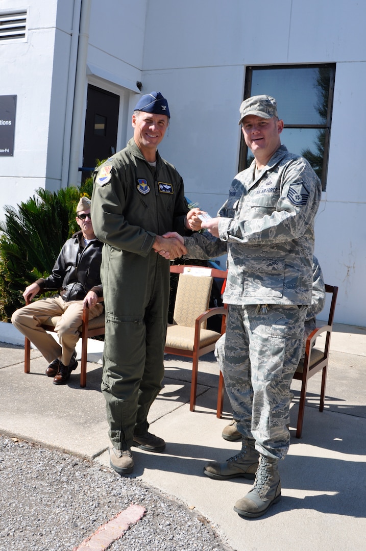 Col. Neil Allen, 479th Flying Training Group commander, hands Master Sgt. William Irvine, 479th Operations Support Squadron Communications Flight superintendent, his access badge for the 479th OSS' Pensacola Regional Communications Facility, Oct. 31 at Naval Air Station Pensacola, Fla.  The 3,400 square-foot facility houses a 23-person communications team that provides a full spectrum of services to all Air Force members in the Pensacola region to include Naval Air Stations Pensacola, Corry Station, and Whiting Field.  (U.S. Navy photo by Janet Thomas)