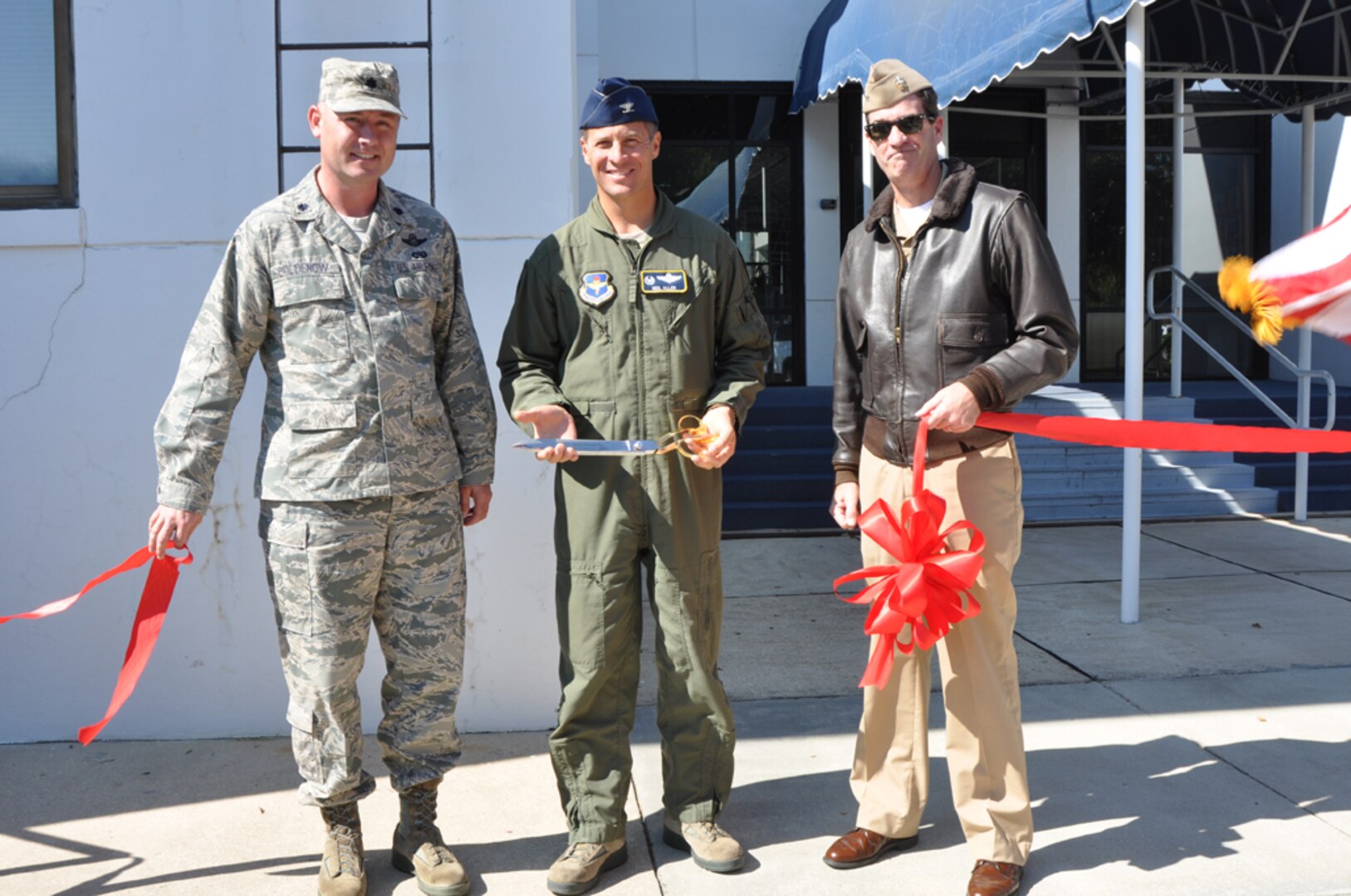 Lt. Col. Justin Boldenow, 479th Operations Support Squadron commander, Col. Neil Allen, 479th Flying Training Group commander, and Navy Capt. Christopher  Plummer, Naval Air Station Pensacola commander, pose for a photo after the ribbon cutting for the 479th OSS' Pensacola Regional Communications Facility, Oct. 31 at NAS Pensacola, Fla.  The 3,400 square-foot facility houses a 23-person communications team that provides a full spectrum of services to all Air Force members in the Pensacola region to include Naval Air Stations Pensacola, Corry Station, and Whiting Field.  (U.S. Navy photo by Janet Thomas)