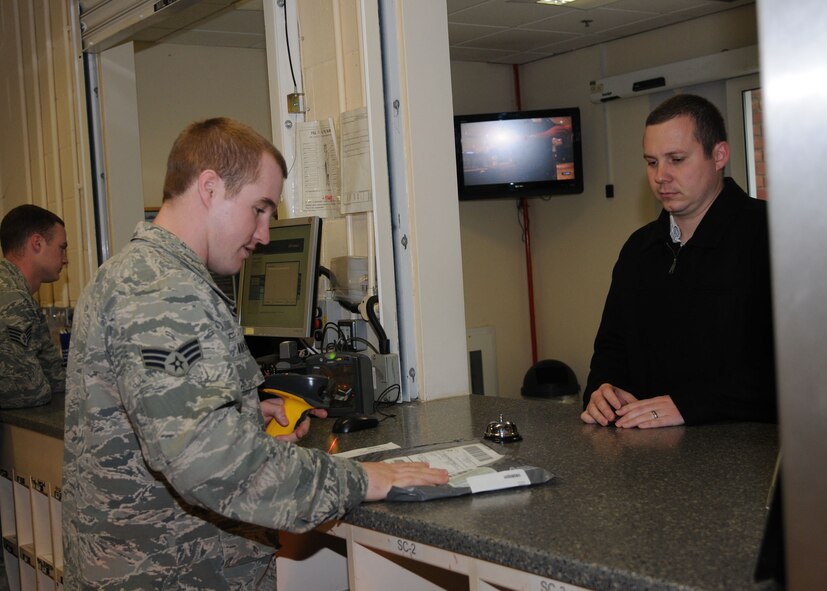 Senior Airman Jeffrey Van Rees, 100th Communications Squadron postal clerk, checks a customer’s packing slip before giving him his package Nov. 6, 2012, at RAF Mildenhall, England.  The post office ships hundreds of packages each holiday season. (U.S. Air Force photo by Airman 1st Class Kelsey Waters/Released)