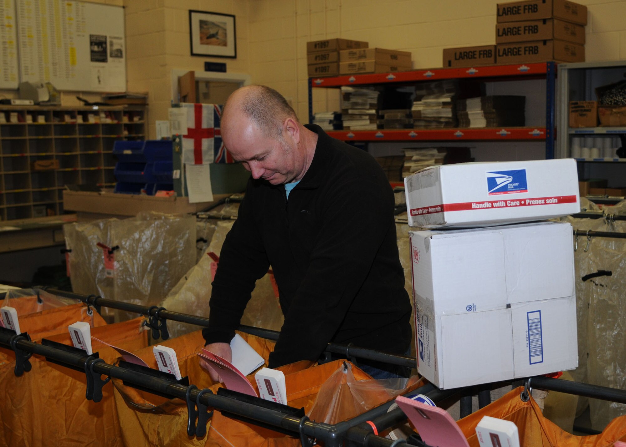 Mark Burrows, 100th Communications Squadron postal clerk, sorts mail to be shipped Nov. 6, 2012, at RAF Mildenhall, England. The post office ships hundreds of packages each holiday season. (U.S. Air Force photo by Airman 1st Class Kelsey Waters/Released)