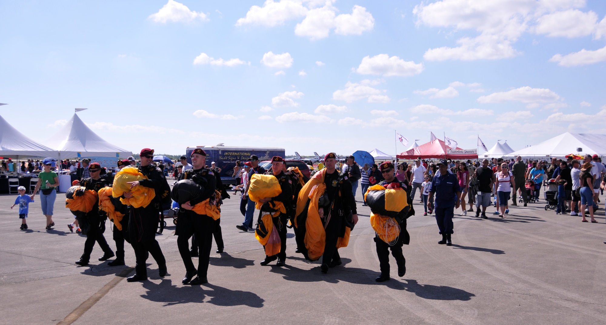 Members of the U.S. Army Golden Knights walk the Wings Over Homestead air show grounds with their parachutes after they touched down, Nov. 4. (U.S. Air Force photo/Staff Sgt. Lou Burton)