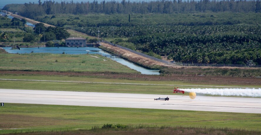 The U.S. Air Force Jet Car deploys its chute during its race with the Pitts S-1, piloted by Mike Wiskus, during the Wings Over Homestead air show Nov. 3. (U.S. Air Force photo/Senior Airman Jacob Jimenez) 