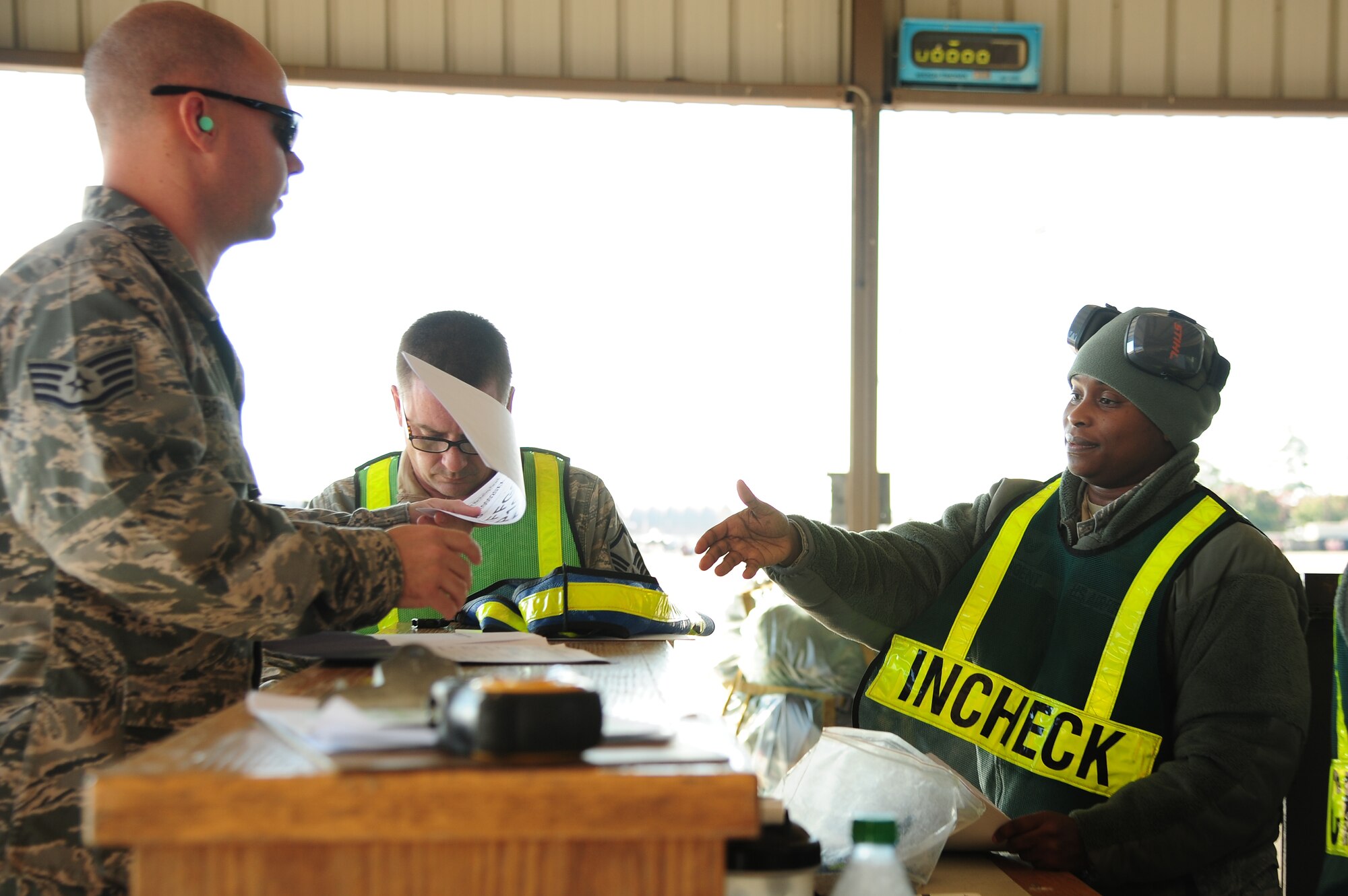 U.S. Air Force Staff Sgt. Chuck Broadway, 4th Fighter Wing public affairs photojournalist, gives deployment marshalling documents to Tech. Sgt. Esi Sargent, 4th Logistics Readiness Squadron traffic management craftsman, for cargo processing during Operational Readiness Exercise Coronet Warrior 12-05 on Seymour Johnson Air Force Base, N.C., Nov. 5, 2012. The documents include information necessary for loadmasters to properly position the cargo on board the aircraft for equal weight distribution. (U.S. Air Force photo/Tech. Sgt. Colette M. Graham/Released)