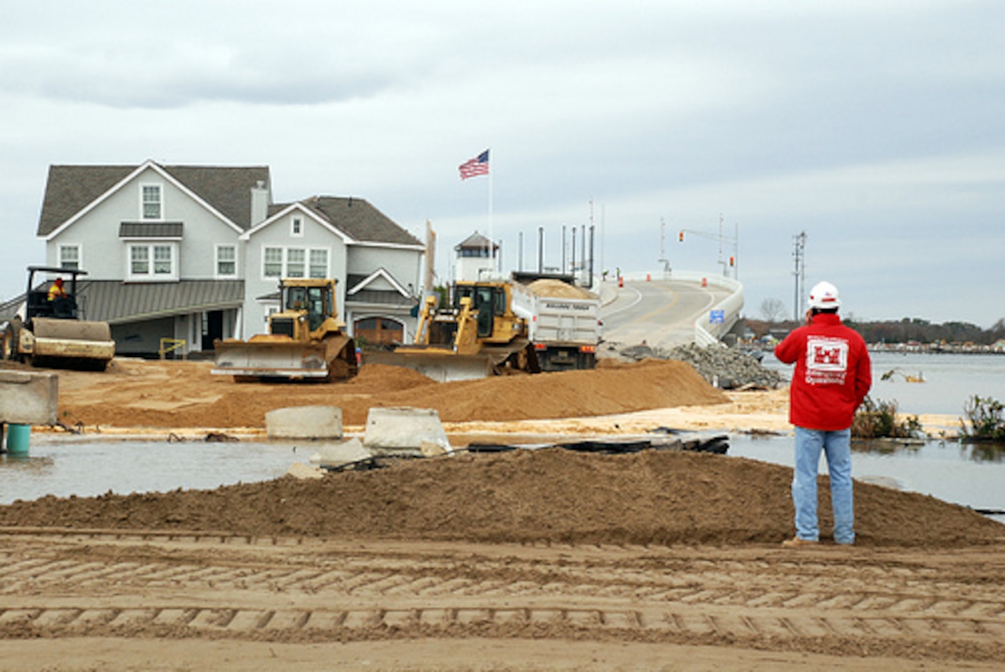 A Corps employee inspects the breach at Mantoloking, NJ as a result of Hurricane Sandy. The island has been cut off since a breach flooded the area at the end of the bridge. The engineers went to Mantoloking  to assess the damage and develop a plan to close the breach and reopen the bridge
