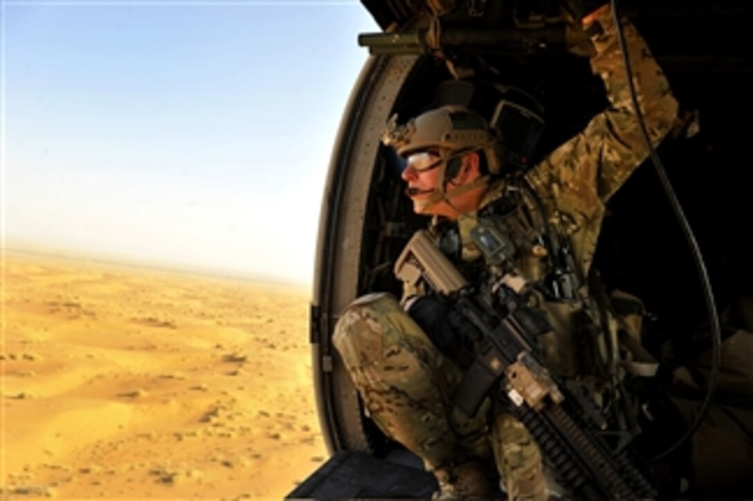 A U.S. Air Force combat rescue officer from the 46th Expeditionary Rescue Squadron looks out over the desert during a training mission in a HH-60G Pave Hawk helicopter near Kandahar Airfield, Afghanistan, on Oct. 29, 2012.  The squadron provides medical evacuation support for the Kandahar Province in southern Afghanistan.  