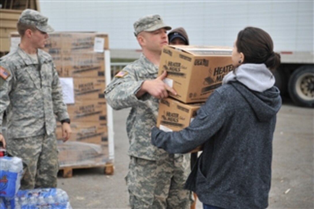 A soldier with the New York Army National Guard hands a box of meals to a resident at a distribution point in Long Beach, N.Y., on Nov. 2, 2012.  The food and water is being provided to people who need assistance after hurricane Sandy took down power lines and caused massive destruction to many homes in the area.  