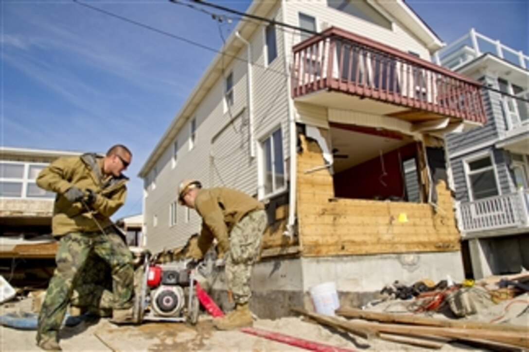 U.S. Navy Petty Officer 1st Class Franklin Horn, left, and Petty Officer 2nd Class Gayland Andrews, right, start a pump to remove water from a flooded basement during relief efforts in Queens, N.Y., on Nov. 6, 2012.  Members of the armed forces are working in the communities to support Hurricane Sandy disaster relief efforts in New York and New Jersey.  Horn is assigned to Mobile Diving and Salvage Unit 2 and Andrews is assigned to Construction Battalion Maintenance Unit 202.  