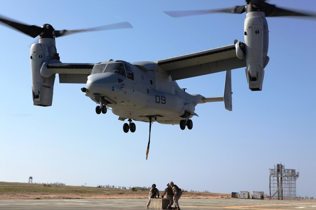 Landing support specialists wait to detach a 7,000-pound cement block from an MV-22B Osprey during dual-point external training at Ie Shima Oct. 25. The Marines supported Marine Medium Tiltrotor Squadron 265 during the training, which consisted of lifting and moving the block to different locations near the landing zone. The landing support specialists are with Combat Logistics Regiment 37, 3rd Marine Logistics Group, III Marine Expeditionary Force. The pilot and crew are with VMM-265, 1st Marine Aircraft Wing, III MEF. 