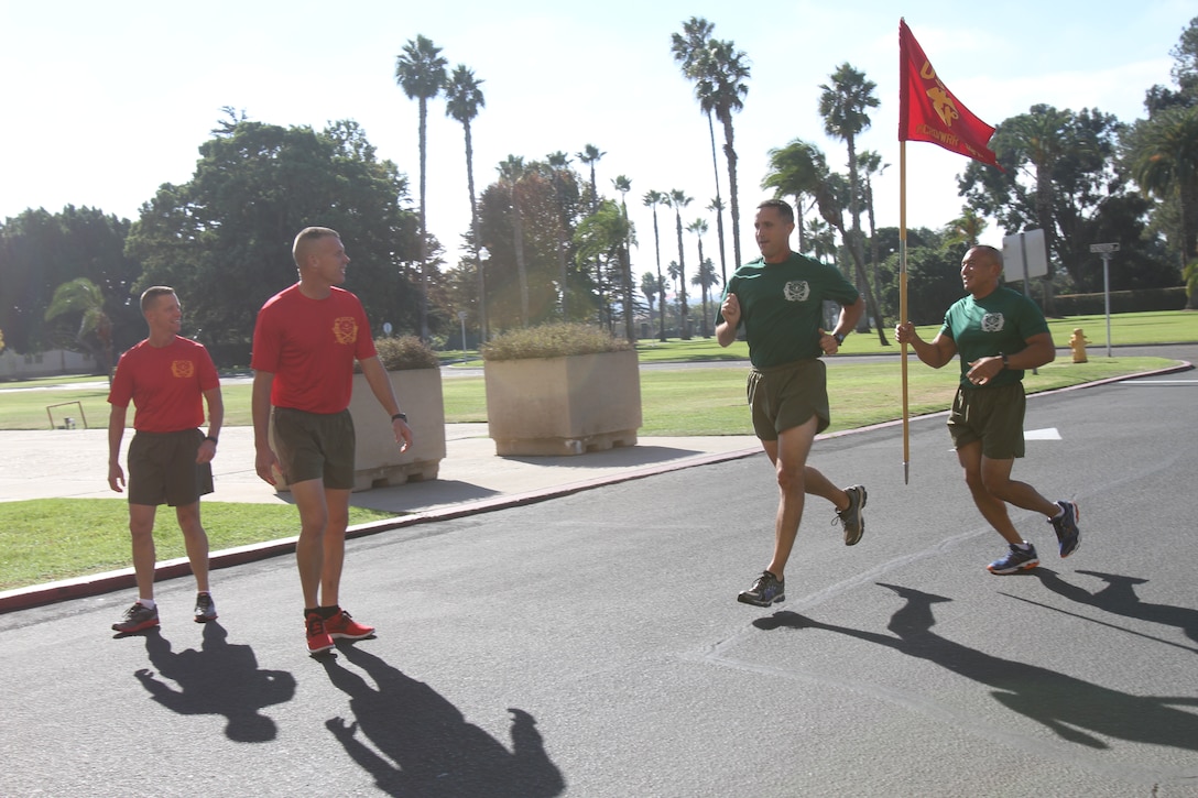 Col. Michael Lee and Sgt. Maj. Peter Siaw, commanding officer and sergeant major of Recruit Training Regiment pass off the Marine Corps Recruit Depot guidon to Lt. Col. Dan Kazmier and Sgt. Maj. Matt Seamans, commanding officer and sergeant major of 1st Recruit Training Battalion during the dedication run Nov. 7 aboard MCRD San Diego. The dedication run is a mile for every year old of the Marine Corp. The Marine Corps is celebrating its 237th birthday.