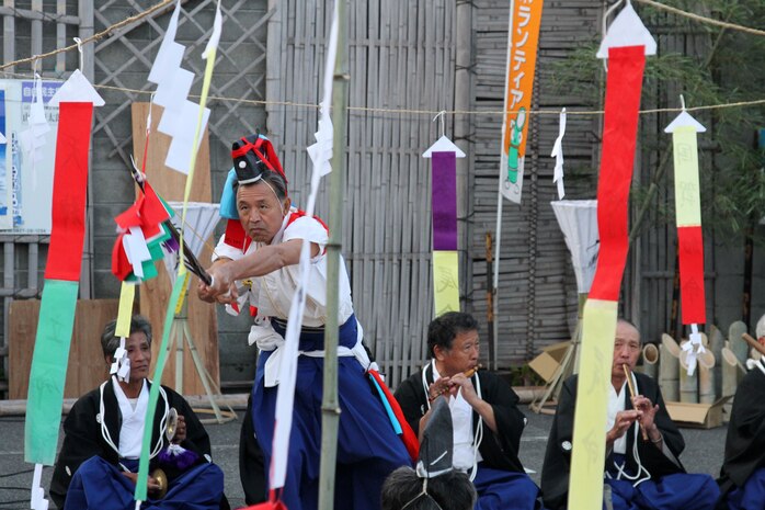 A Japanese man dressed in ceremonial attire performs for a crowd during the Kintai Art Festival near the Kintai Bridge Nov. 3, 2012. When the dance finished, the same location was later used to display a congratulatory monument to the completion of the Iwakuni Kintai-kyo Airport.