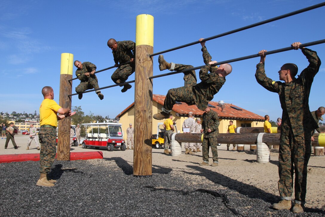 Recruits of Company H, 2nd Recruit Training Battalion, climb over a set of bars during the obstacle course aboard Marine Corps Recruit Depot San Diego Nov. 1. The portion of the course required recruits to maneuver over the top bar, by using the bottom bar as support. 