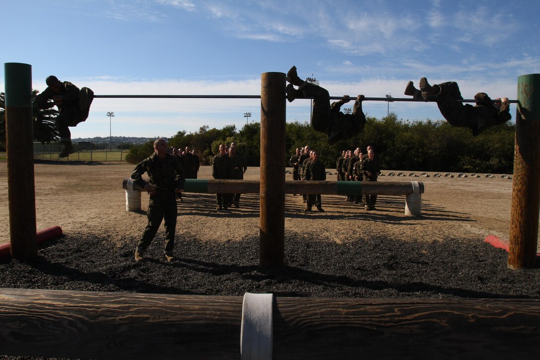 Recruits of Company H, 2nd Recruit Training Battalion, climb over a bar during the obstacle course aboard Marine Corps Recruit Depot San Diego Nov. 1. Recruits are taught one of two methods when maneuvering over the bar, the chicken wing or college-boy roll. 