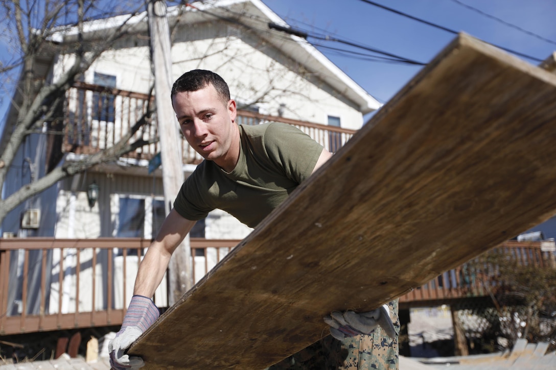 Cpl. Travis Pender, an embarkation specialist with 8th Engineer Support Battalion, 2nd Marine Logistics Group moves debris in a neighborhood in Breezy Point, N.Y., Nov. 6. The Marines were cleaning the area in the neighborhood in support of humanitarian operations with the Federal Emergency Management Agency after Hurricane Sandy.
