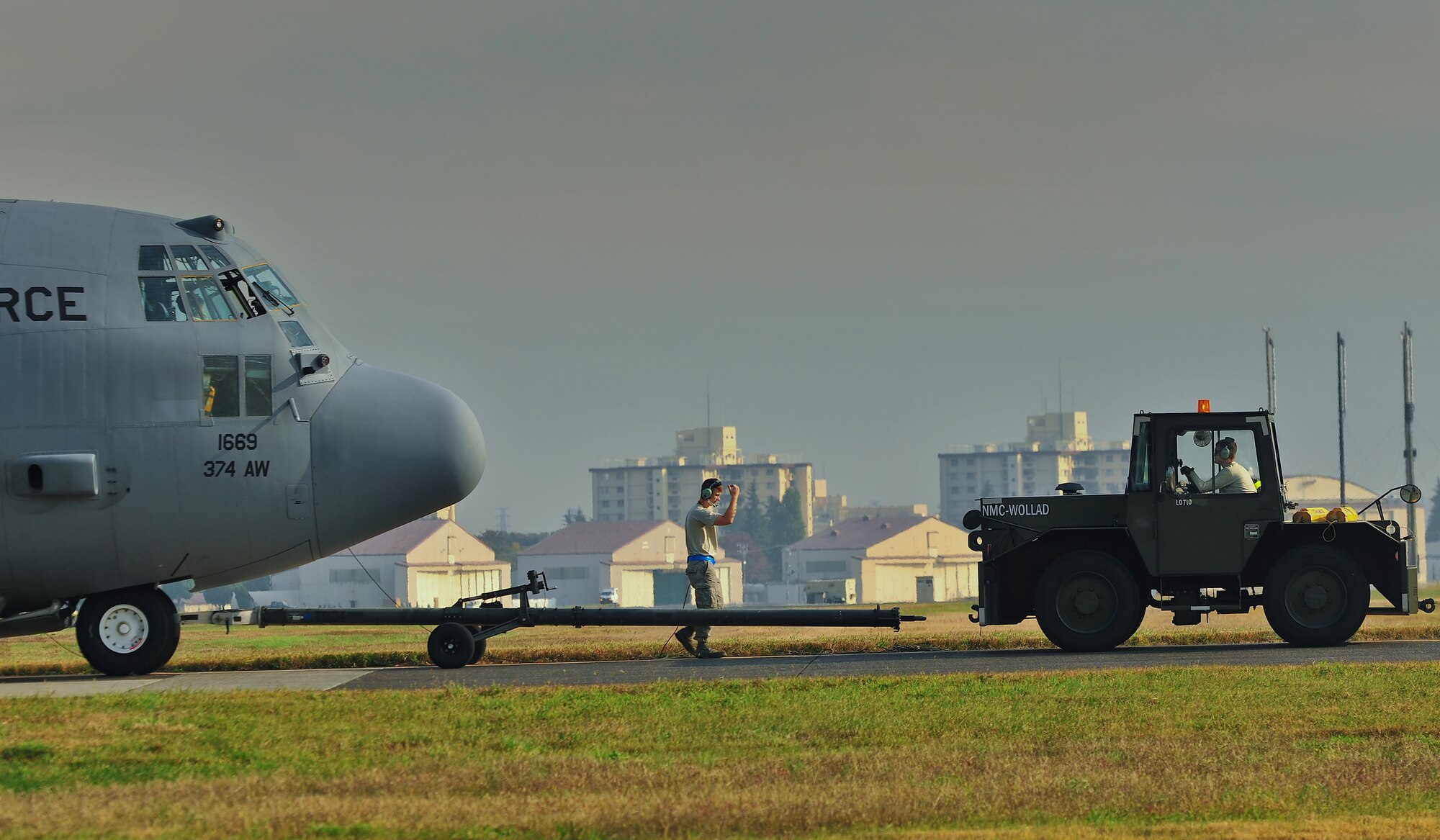 YOKOTA AIR BASE, Japan -- Airmen from the 374th Aircraft Maintenance Squadron tow a C-130 Hercules to a parking spot during an operational readiness exercise at Yokota Air Base, Japan, Nov. 5, 2012. The 374th Airlift Wing exercises and inspections office organizes regularly scheduled exercises to test the capability of base personnel to respond to a variety of possible accidents and incidents. (U.S. Air Force photo by Osakabe Yasuo)