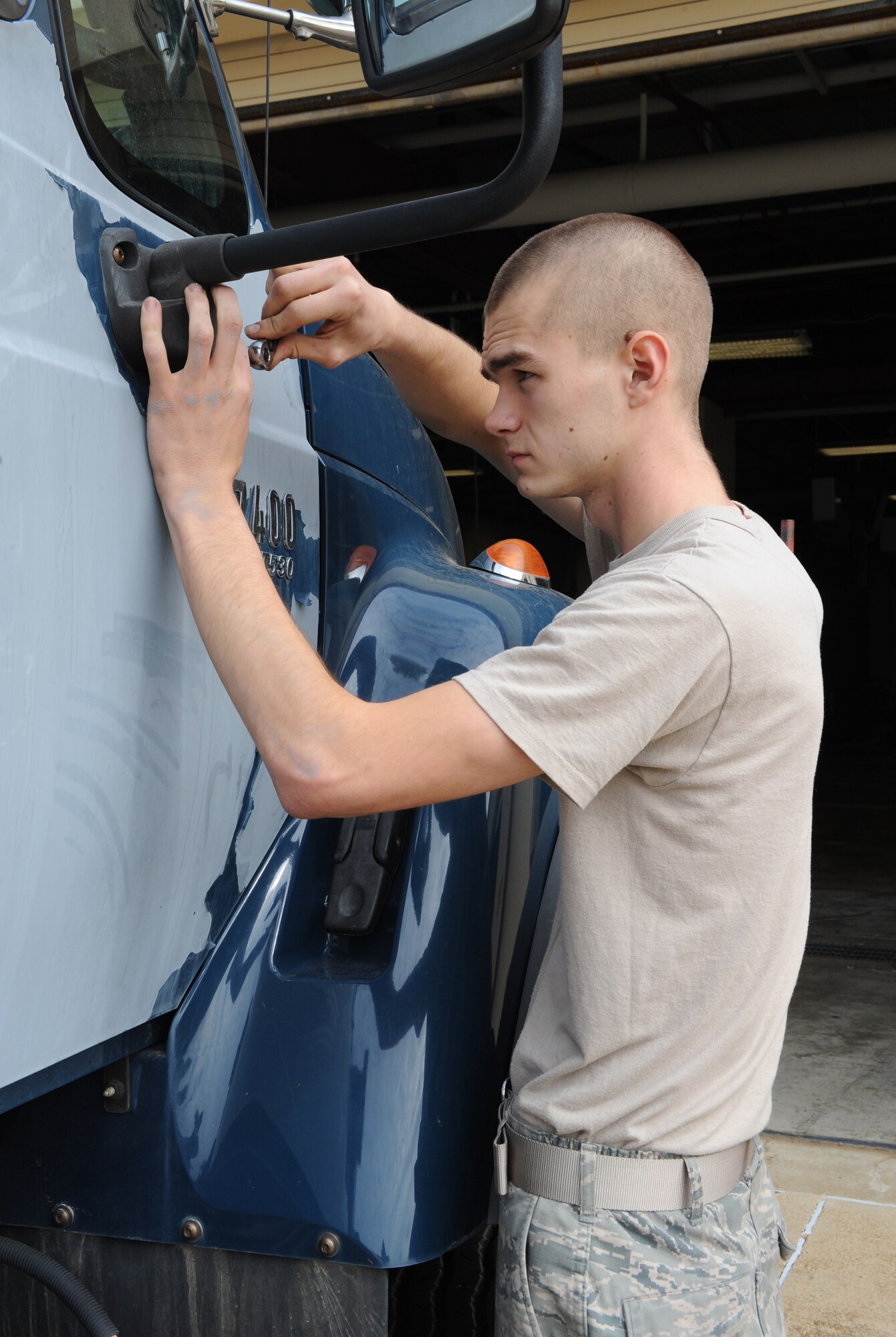Airman 1st Class Kenneth Bates, 2nd Logistics Readiness Squadron Allied Trades section apprentice, unscrews a side-view mirror from a vehicle on Barksdale Air Force Base, La., Nov. 5. The rear-view mirror and all of the outer accoutrements on the vehicle are taken off in preparation for the painting process. (U.S. Air Force photo/Airman 1st Class Benjamin Gonsier)(RELEASED)
