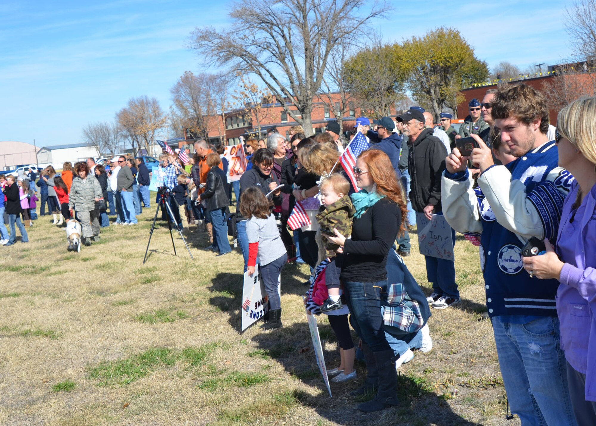 Family and friends of Missouri Air National Guard members at Rosecrans Air National Base, St. Joseph, Mo., Nov. 7 hold banners and prepare to welcome nearly 50 deployed Airmen from overseas contingency operations in Southwest Asia. The citizen-Airmen with the 139th Airlift Wing left on Independence Day and returned just short of Veterans Day. (U.S. Air Force photo/Master Sgt. Mike R. Smith, 139th Airlift Wing) (Released)