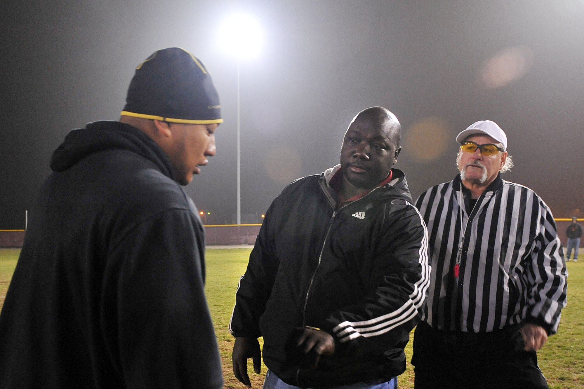 U.S. Air Force Staff Sgt. Timmy Johnson, with the 55th Intelligence Support Squadron, watches Tommie Frazier, former University of Nebraska football player, flip the coin at the start of the intramural flag football game between 55th ISS and U.S. Strategic Command on Offutt Air Force Base, Neb., Nov. 5. The 55th ISS at Offutt Air Force Base has a unique mission, combining the efforts of three separate intelligence squadrons: the 97th Intelligence Squadron at Offutt AFB, the 488th Intelligence Squadron at Royal Air Force Mildenhall, United Kingdom and the 390th Intelligence Squadron at Kadena Air Base, Japan. (U.S. Air Force photo by Charles Haymond/Released)