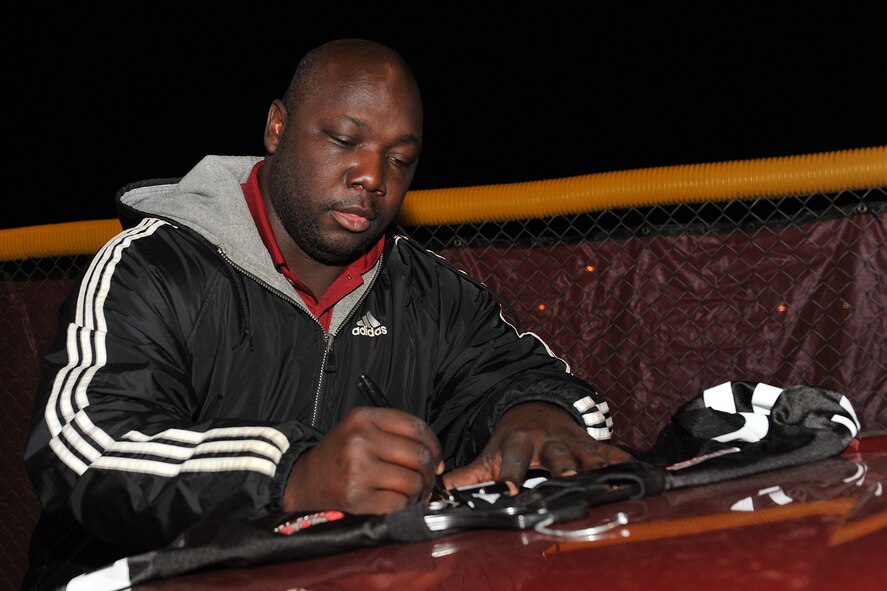 Tommie Frazier, former University of Nebraska football player, autographs a Nebraska jersey before intramural flag football game between 55th Intelligence Support Squadron and U.S. Strategic Command on Offutt Air Force Base, Neb., Nov. 5. Frazier was the first Husker ever to win the Johnny Unitas Golden Arm Award, finished second in the Heisman Trophy voting, received the UPI's Player-of-the-Year and The Sporting News Offensive Player-of-the-Year awards, and was a finalist for the Davey O'Brien, Maxwell and the Walter Camp Player-of-the-Year awards.  (U.S. Air Force photo by Charles Haymond/Released)