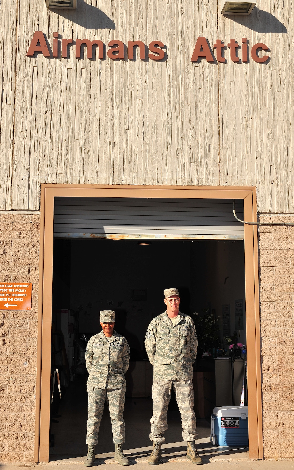 U.S. Air Force Master Sgt. Tibetha Pascal, 355th Force Support Squadron base lodging superintendant, and Master Sgt. Christopher Rasco, 355th Maintenance Operations Squadron loading standardization crew chief, pose for a photo in front of the Airman’s Attic on Davis-Monthan Air Force Base, Ariz., Nov. 6, 2012. Pascal and Rasco are council members for the Airman’s Attic. (U.S. Air Force Photo by Airman 1st Class Josh Slavin/Released)