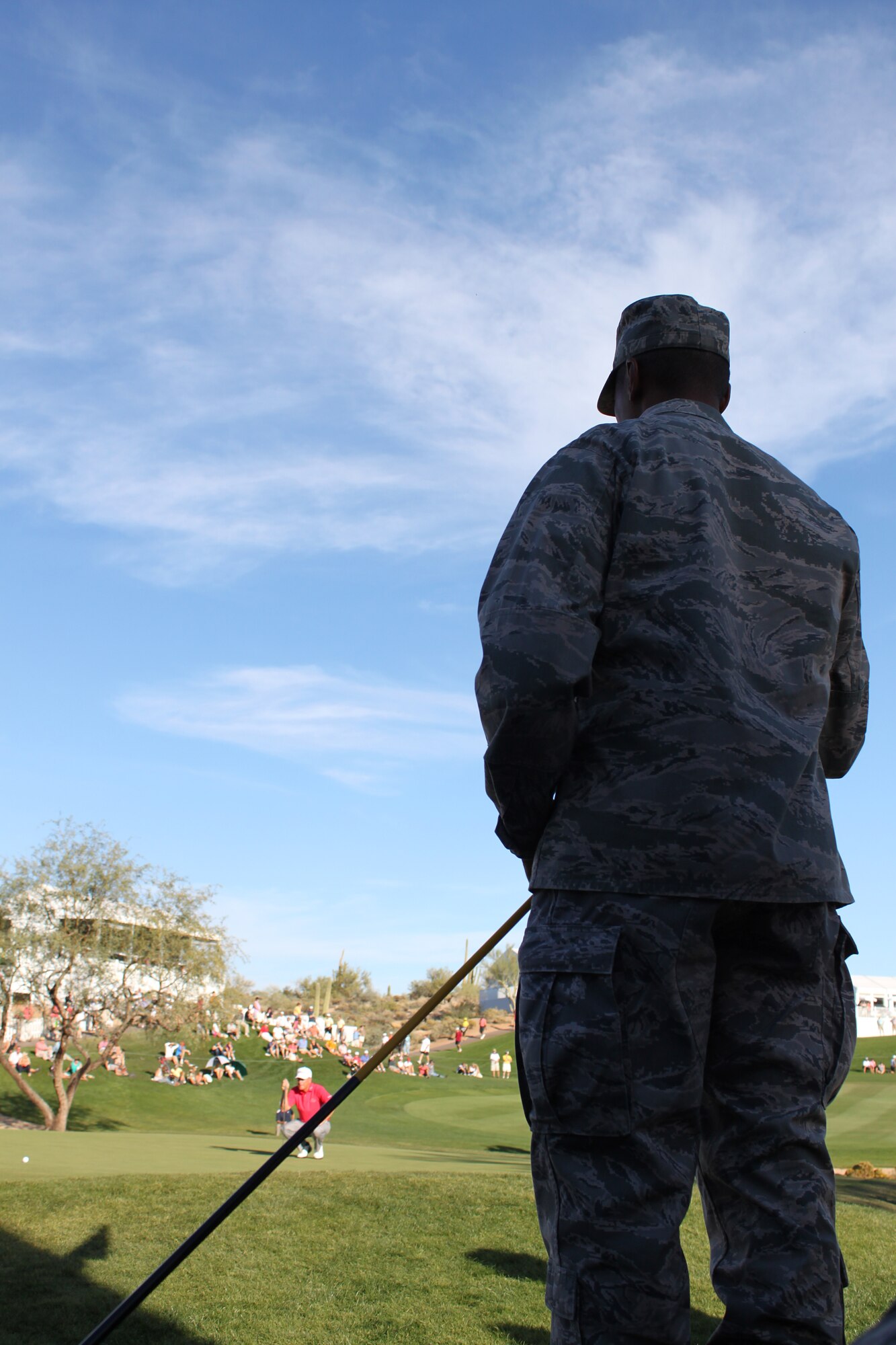 Capt. Derrick Young, Operations Officer, 944th Force Support Squadron, watches at the 18th hole as professionals finish the Cochise Geronimo Course at Desert Mountain in Scottsdale, Ariz. Nov. 4. Young served as an announcer for the hole during Military Appreciation at the Charles Schwab Cup Championship. (U.S. Air Force Photo by Tech. Sgt. Meredith Mingledorff)