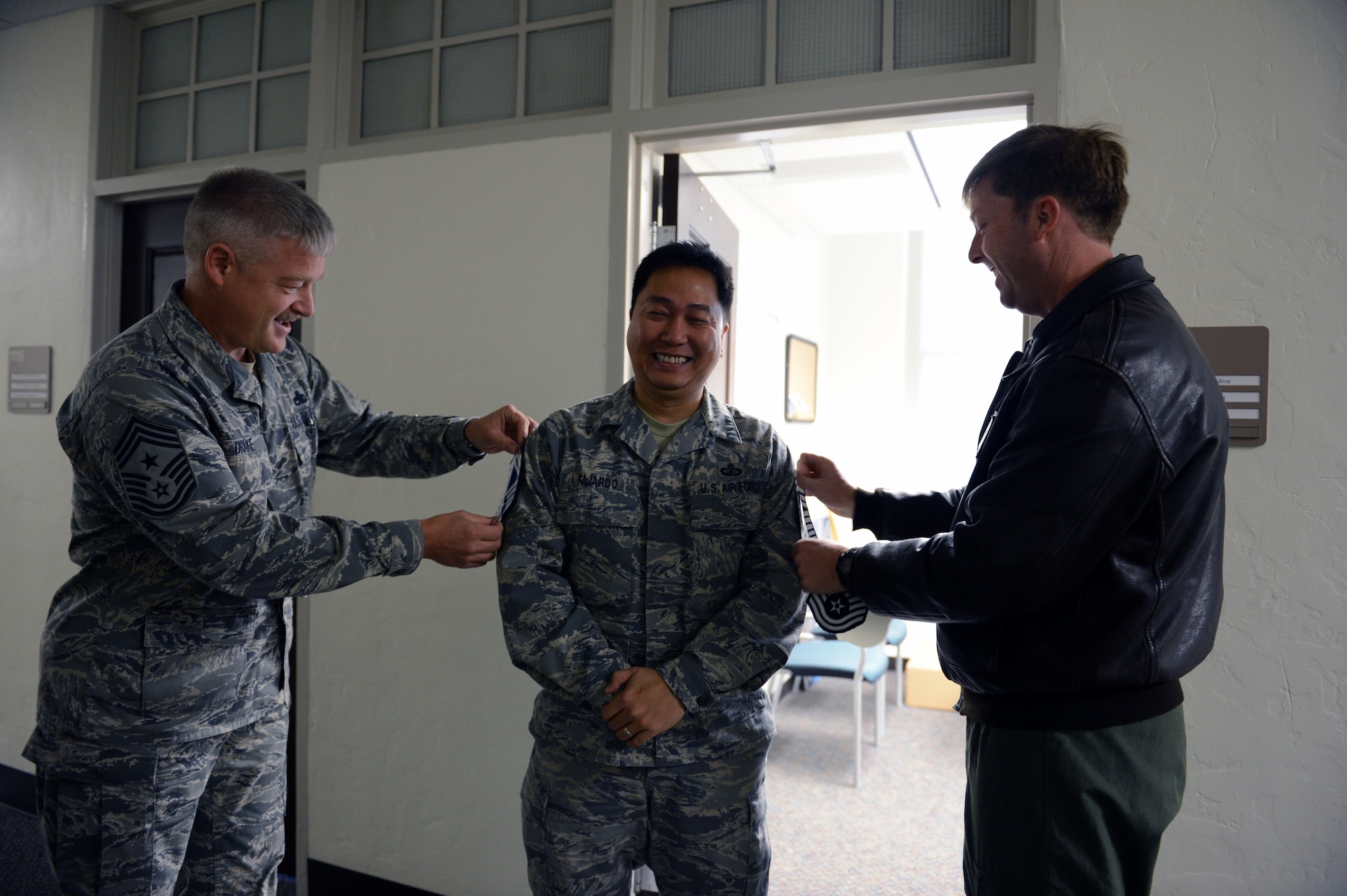 Col. Wyn Elder (right), 62nd Airlift Wing commander, and Chief Master Sgt. Gordon Drake, 62nd AW command chief, pin on chief master sergeant stripes to Senior Master Sgt. Armando Fajardo (center), 62nd Comptroller Squadron superintendent, Nov. 8, 2012, at Joint Base Lewis-McChord, Wash. Fajardo is one of three senior master sergeants from the 62nd AW selected for promotion to chief master sergeant. (U.S. Air Force photo/Staff Sgt. Frances Kriss)