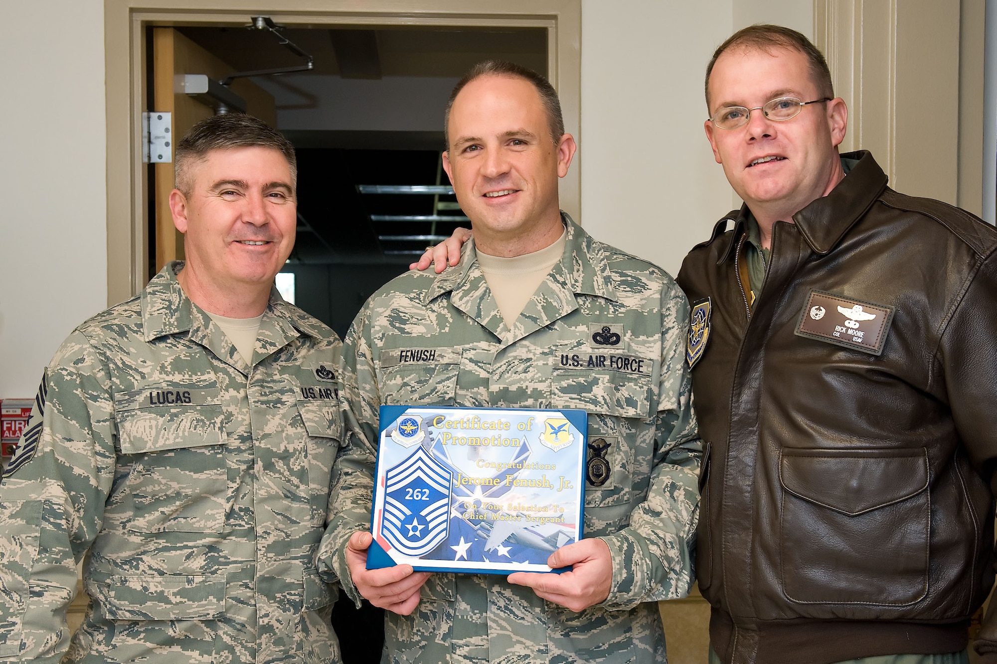 Senior Master Sgt. Jerome Fenush, center, 436th Security Forces Squadron, receives his chief master sergeant line number of 262  Nov. 8, 2012, at Dover Air Force Base, Del. Chief Master Sgt. James Lucas, left, 436th Airlift Wing command chief, and Col. Rick Moore, 436th AW commander, presented line numbers to three chief-selects. (U.S. Air Force photo by Roland Balik)
