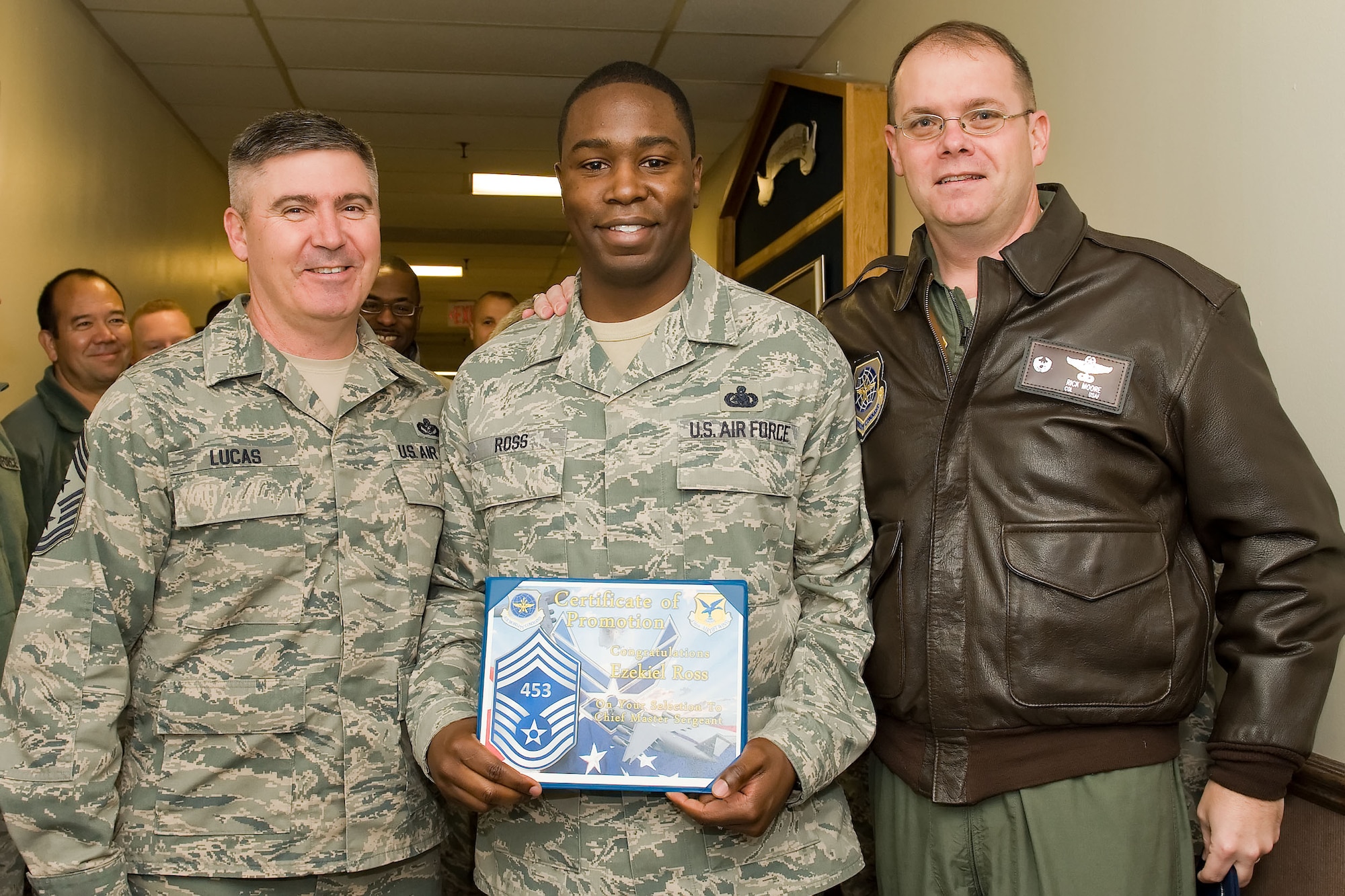 Senior Master Sgt. Ezekiel Ross, center, 436th Logistics Readiness Squadron, receives his chief master sergeant line number of 453  Nov. 8, 2012, at Dover Air Force Base, Del. Chief Master Sgt. James Lucas, left, 436th Airlift Wing command chief, and Col. Rick Moore, 436th AW commander, presented line numbers to three chief-selects. (U.S. Air Force photo by Roland Balik)