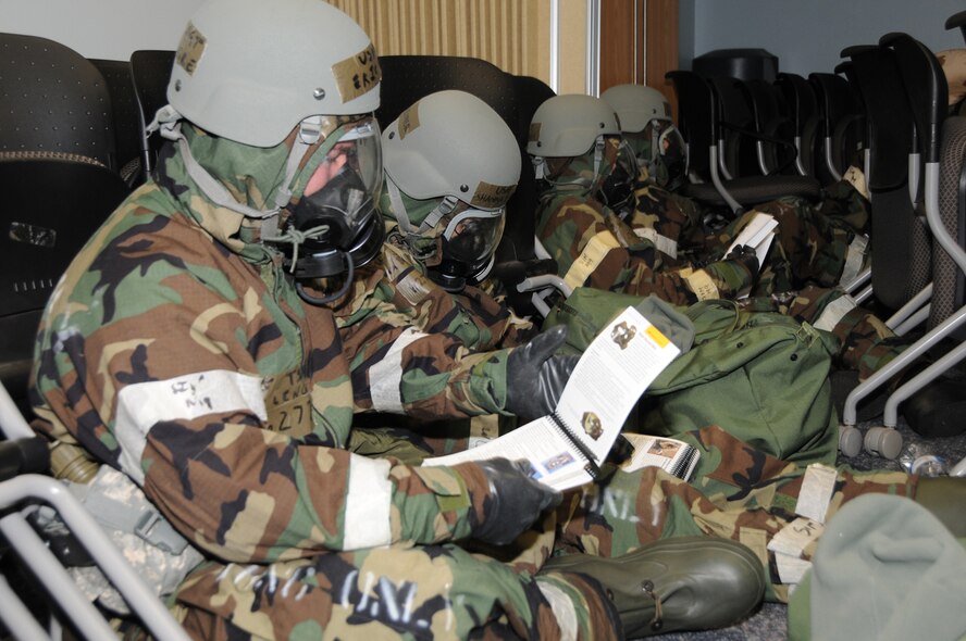 Members of the 193rd Special Operations Force Support Squadron refer to their Airman's Manual after going into mission oriented position posture level 4 during an Operational Readiness Inspection. The inspection included four phases that were spread out during the course of nine months. The 193rd Special Operations Wing scored an overall excellent on the ORI. (U.S. Air Force Photo by Tech. Sgt Culeen Shaffer/Released)