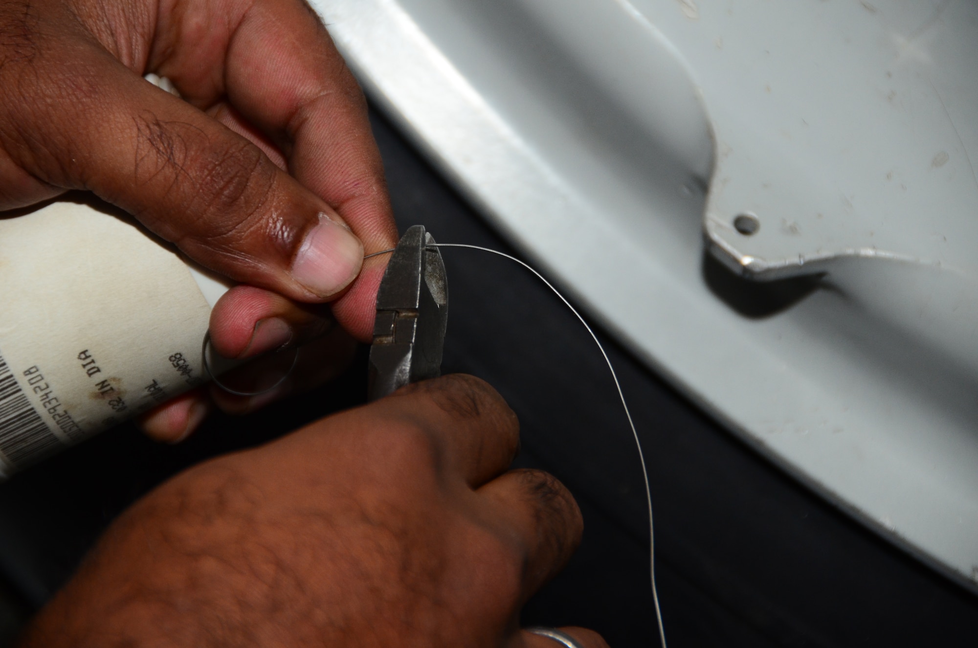 A member of the Indian air force cuts safety wire to attach to the C-17 Globemaster III’s tire prior to changing the aircraft’s tire during a simulated C-17 tire change Nov. 2, at Joint Base Charleston, S.C. The tire change was part of the IAF’s training with the 373rd  Training Squadron Detachment 5. The mission of the 373rd TRS Detachment 5 is to provide aircraft maintenance to the Department of Defense and its allies. About 100 IAF members have been training in the various aspects of C-17 maintenance here. (U.S. Air Force photo/Senior Airman William O'Brien)