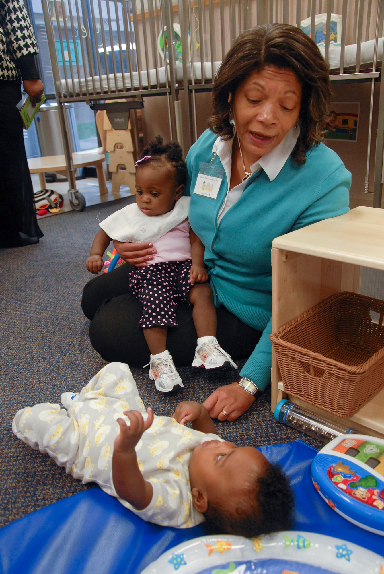 Evelyn McDew, wife of Lt. Gen. Darren McDew, 18th Air Force commander, holds and plays with some infants at one of the Child Development Centers here Nov. 6. (U.S. Air Force photo by Airman 1st Class Regina Agoha)
