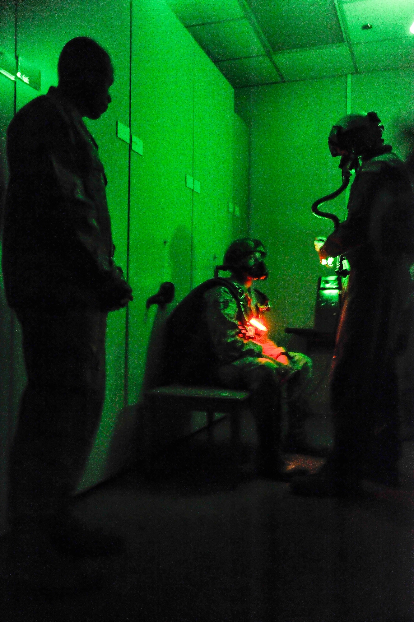 Staff Sgt. Allen Smith (seated) and Tech. Sgt. Steve McShane, both 19th Aerospace Medicine Squadron physiology technicians, demonstrate an oxygen bottle replacement for Lt. Gen. Darren McDew, 18th Air Force commander, here Nov. 6. Bottle replacement is one of several duties physiology technicians perform in flight to support aircrew members. (U.S. Air Force photo by Staff Sgt. Russ Scalf)
