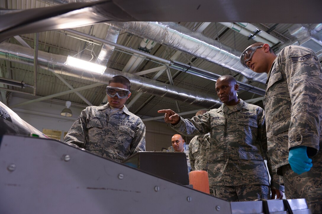 Senior Airman Eric Lobina (left) and Senior Airman Keith Winn, 19th Aircraft Maintenance Squadron aerospace propulsion journeymen, discuss a propeller assembly operational test with Lt. Gen. Darren McDew, 18th Air Force commander, during his visit here Nov. 6. The test ensures that there are no leaks, and the propeller blades are set to the proper angle. (U.S. Air Force photo by Staff Sgt. Russ Scalf)

