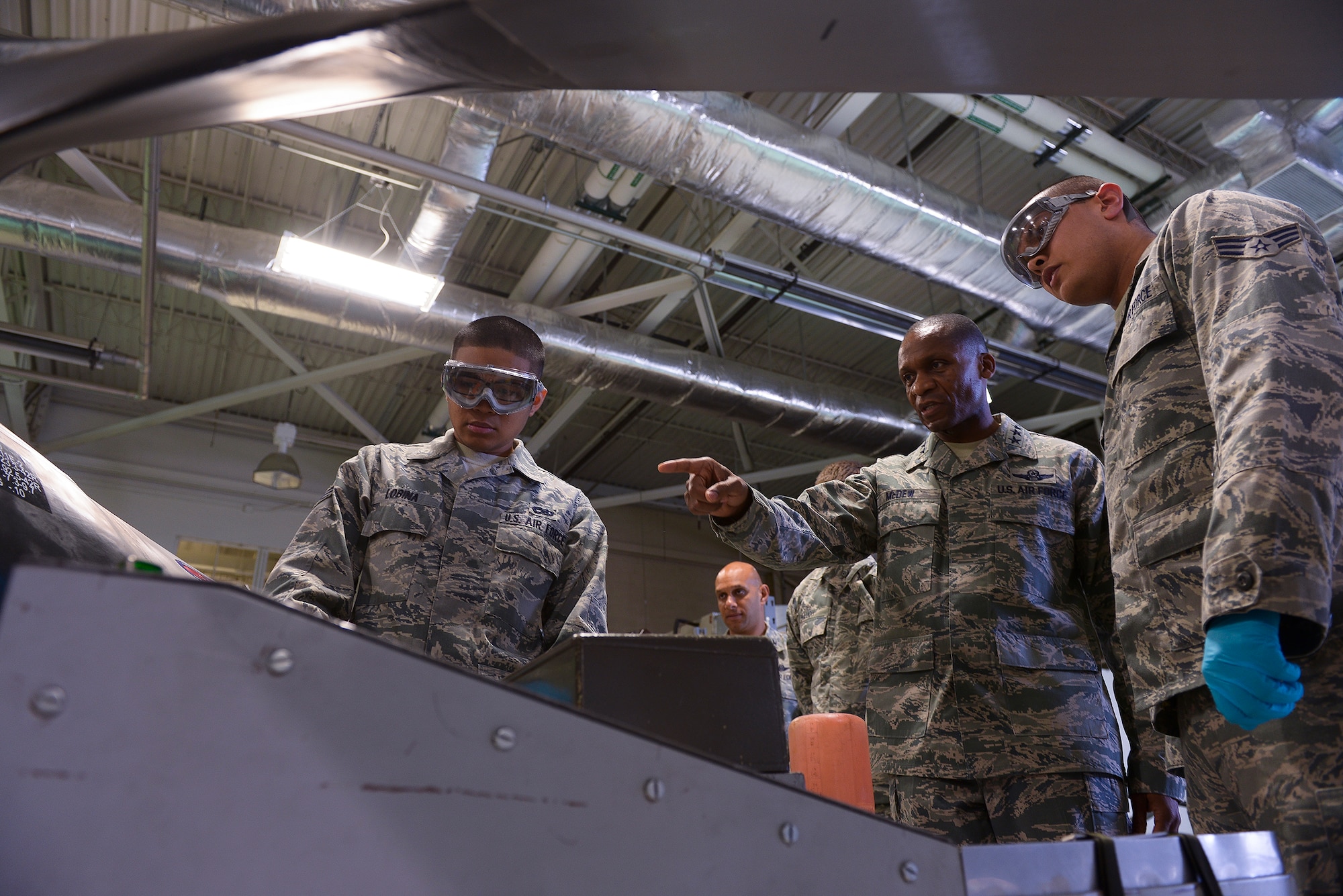 Senior Airman Eric Lobina (left) and Senior Airman Keith Winn, 19th Aircraft Maintenance Squadron aerospace propulsion journeymen, discuss a propeller assembly operational test with Lt. Gen. Darren McDew, 18th Air Force commander, during his visit here Nov. 6. The test ensures that there are no leaks, and the propeller blades are set to the proper angle. (U.S. Air Force photo by Staff Sgt. Russ Scalf)
